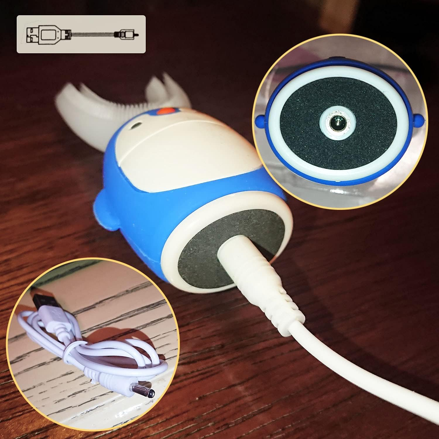 Eine blau-weiße Zahnbürste mit Ladekabel auf einer Holzoberfläche.