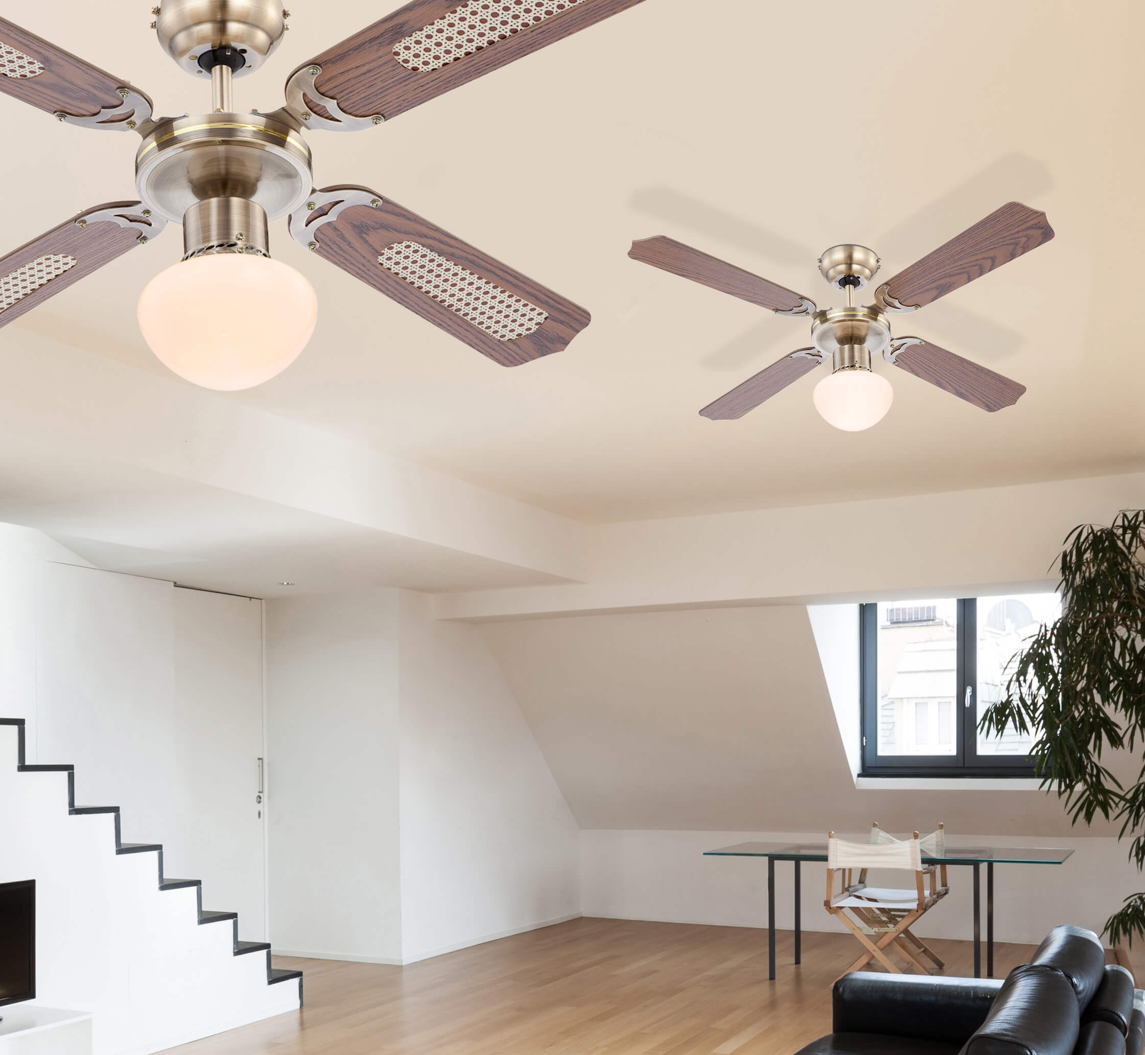 Zwei Deckenventilatoren. Jeder hat fünf Flügel. Holzblätter. Lichter. Weiße Wände. Wohnzimmer.