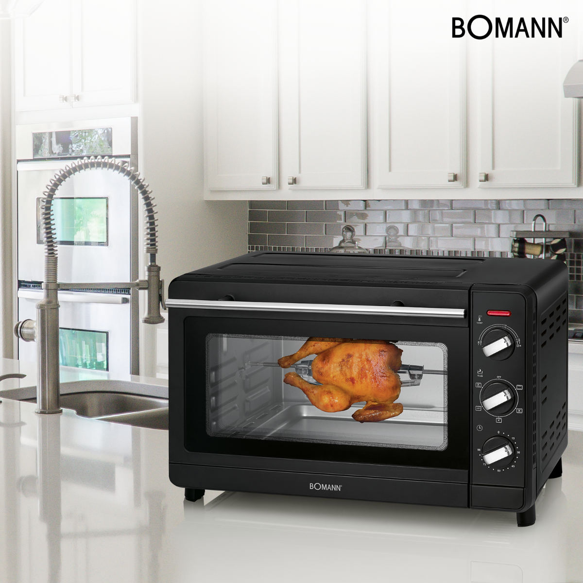 Forno nero con pollo cotto dentro. In una cucina con mobili bianchi.