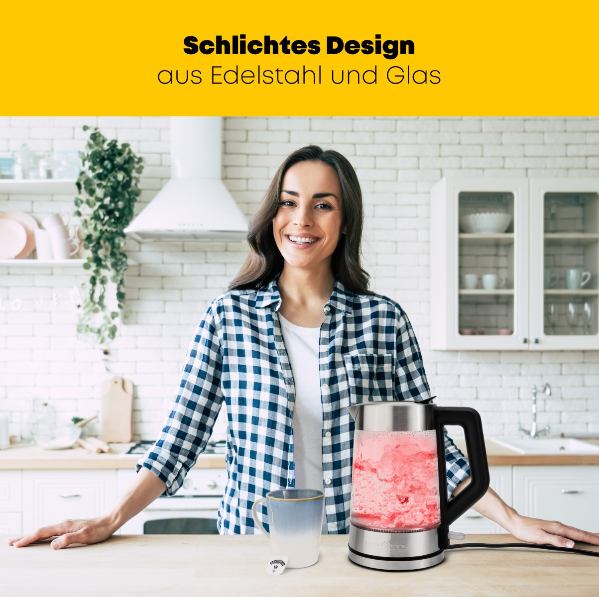 Kobieta uśmiecha się w kuchni, trzymając czerwoną, podświetlaną czajnik elektryczny.