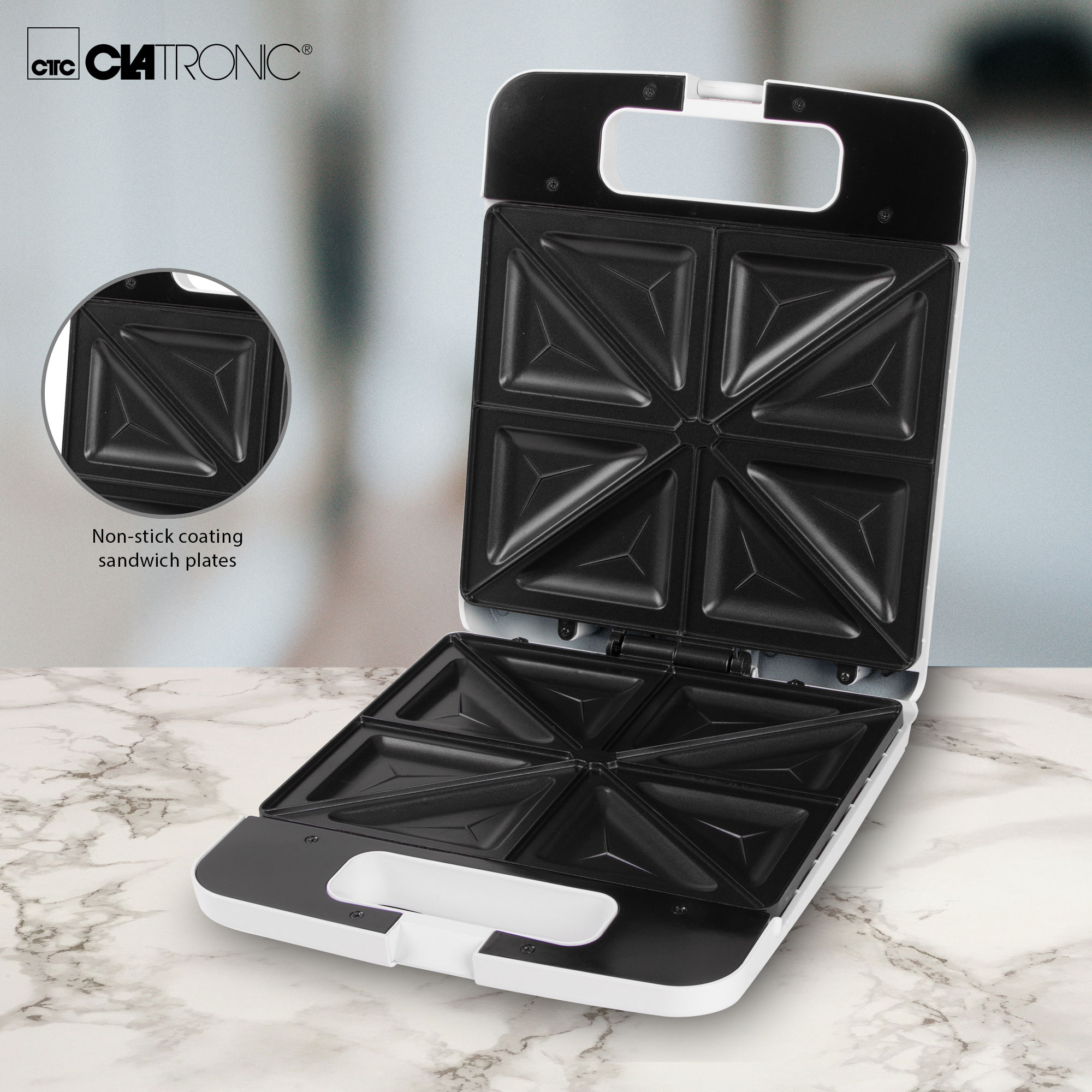 Otwarta biało-czarna opiekacz do kanapek z nieprzywierającymi płytami. Małe koło pokazuje płytę.