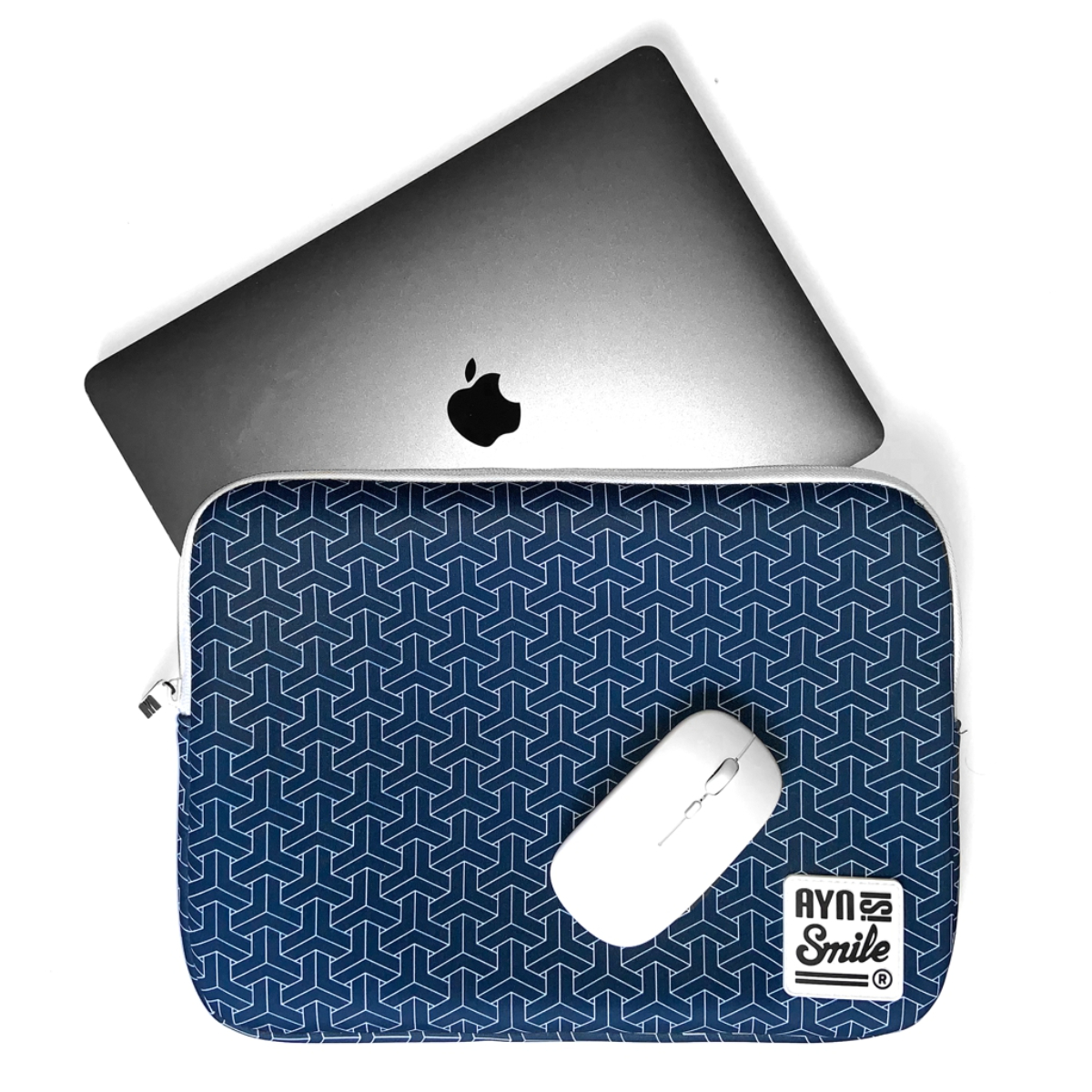 Portátil, ratón y funda sobre blanco. La funda es azul con un patrón blanco. El portátil es gris.