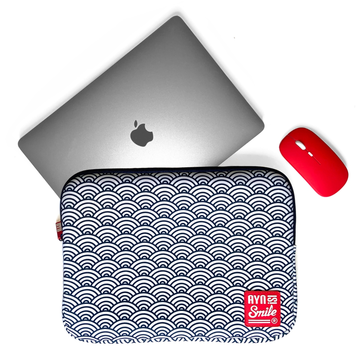 Laptop, ratón rojo y funda para portátil con patrón de olas azul y blanco.