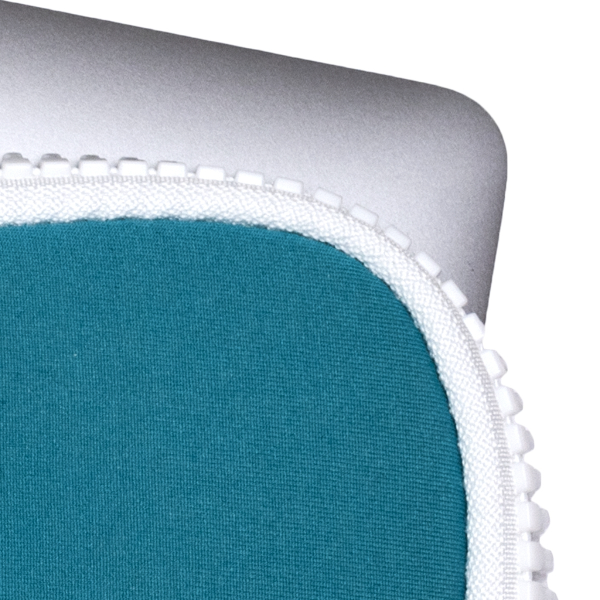 Primer plano de una esquina de portátil con tela turquesa y cremallera blanca.