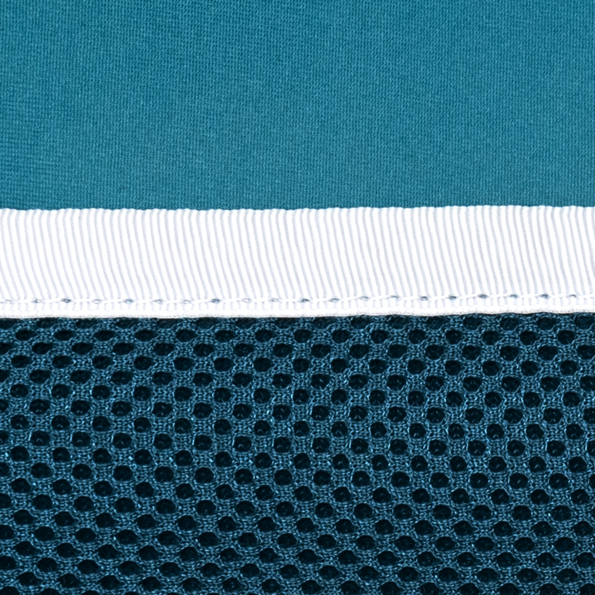 Primer plano de capas de tela: parte superior turquesa, franja blanca e inferior de malla azul oscuro.