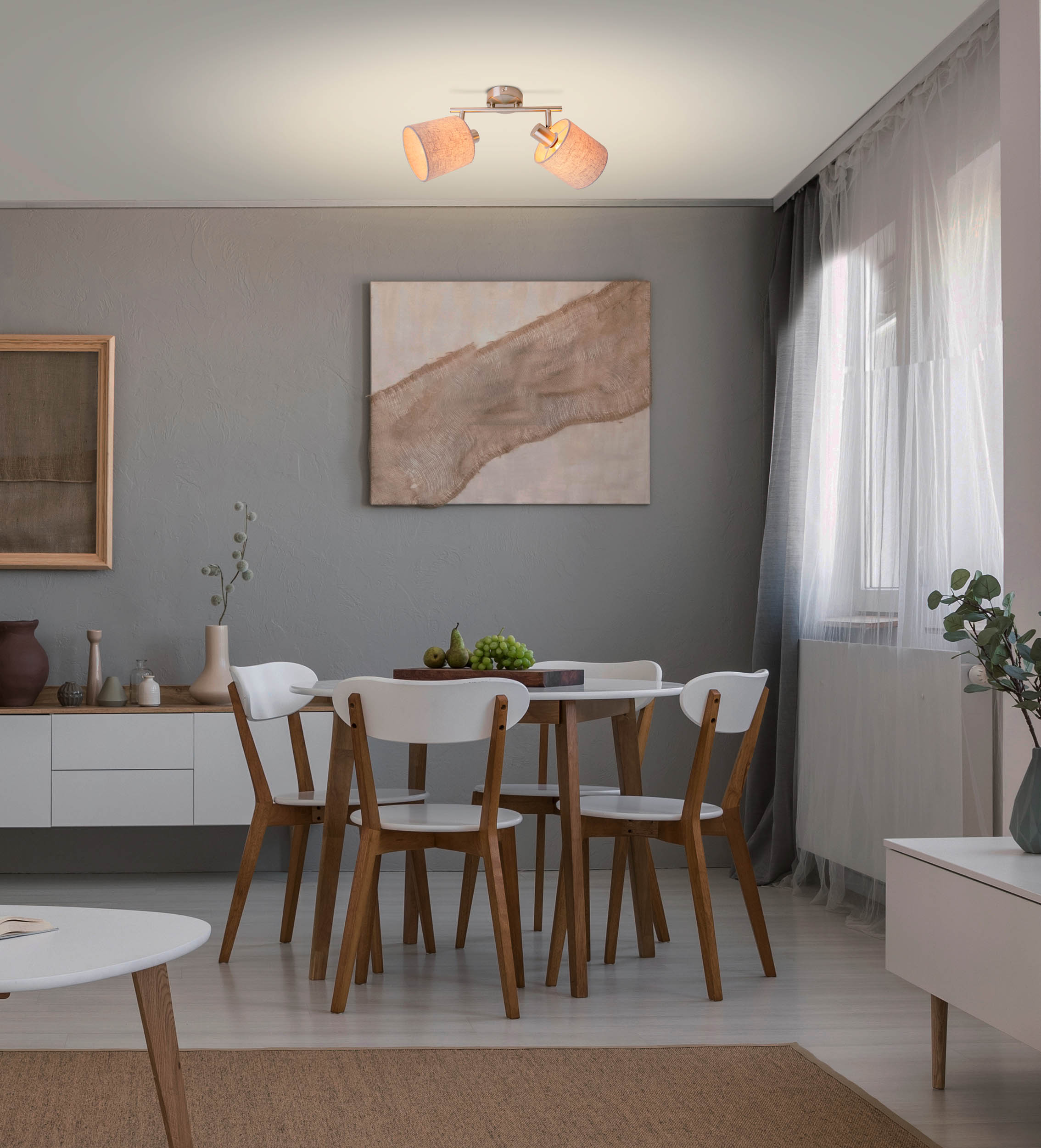 Ein Esszimmer mit Tisch und vier Stühlen. An der Wand befindet sich ein Gemälde und eine Leuchte.