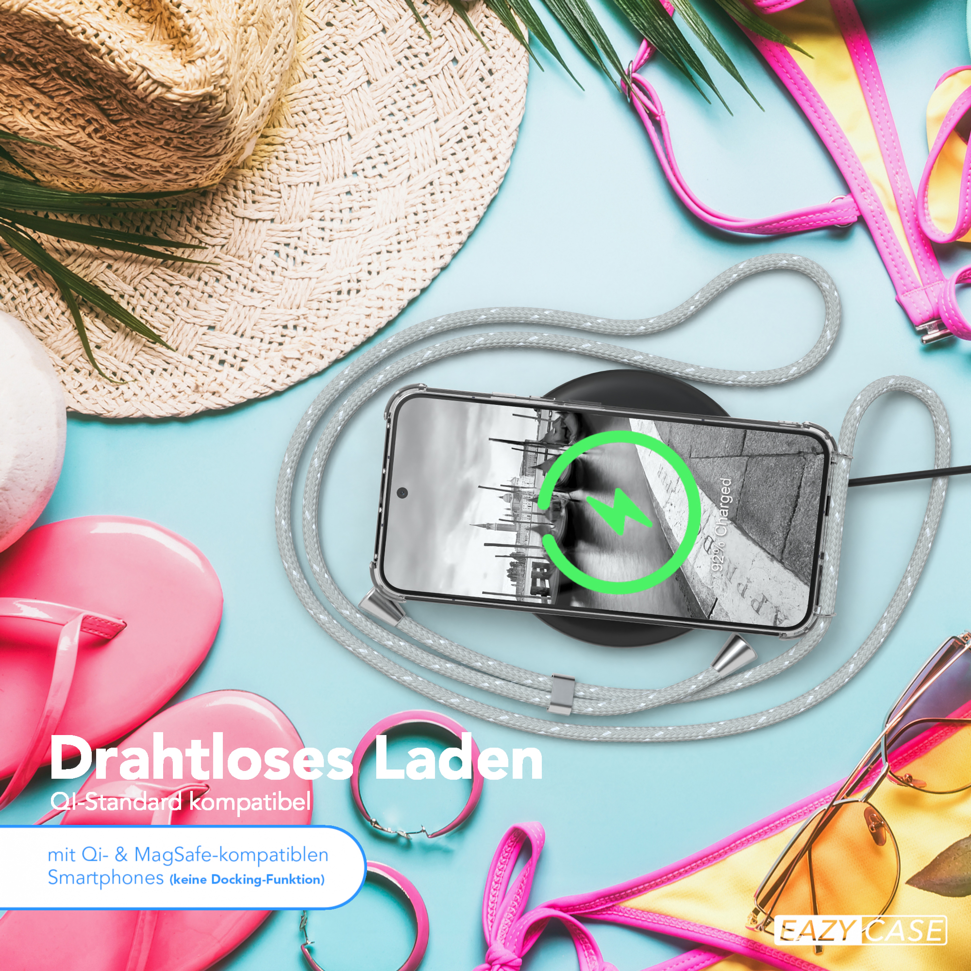 Ein Telefon mit Ladepad. Sonnenbrille, Strandhut und Bikini-Oberteil sind auch sichtbar.