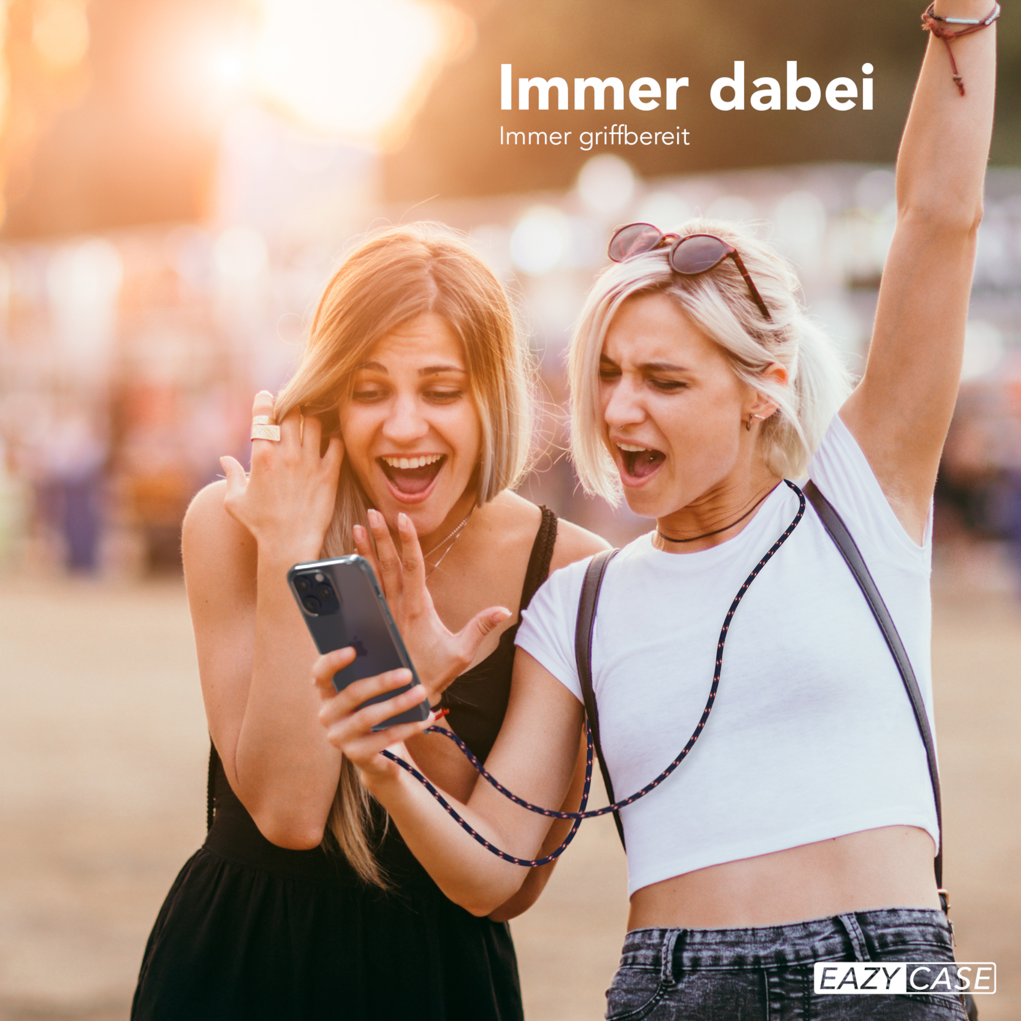Zwei Frauen, die auf ein Telefon schauen, mit einem Kabel.