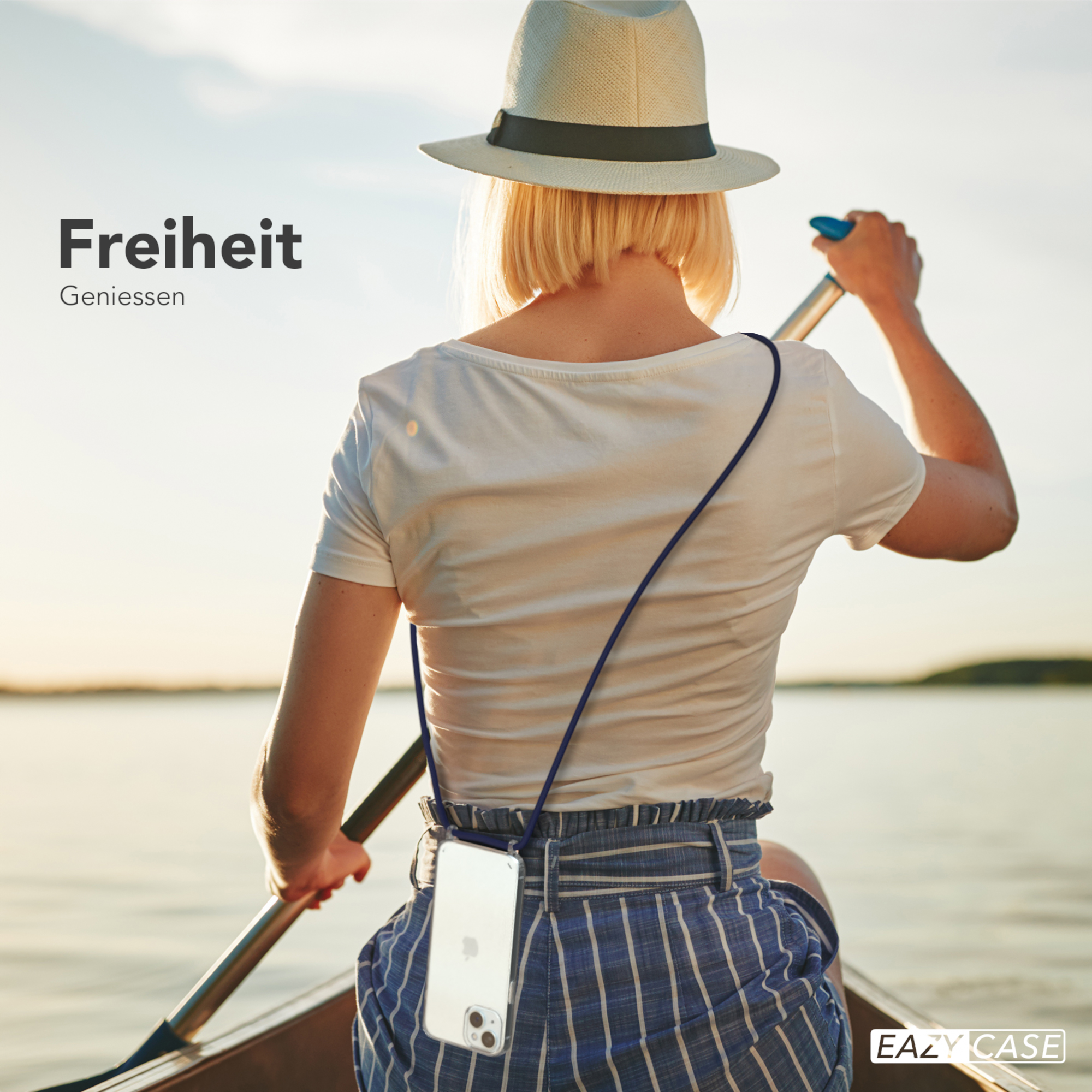 Frau in einem Boot beim Paddeln, mit Hut und Handy am Umhängeband.