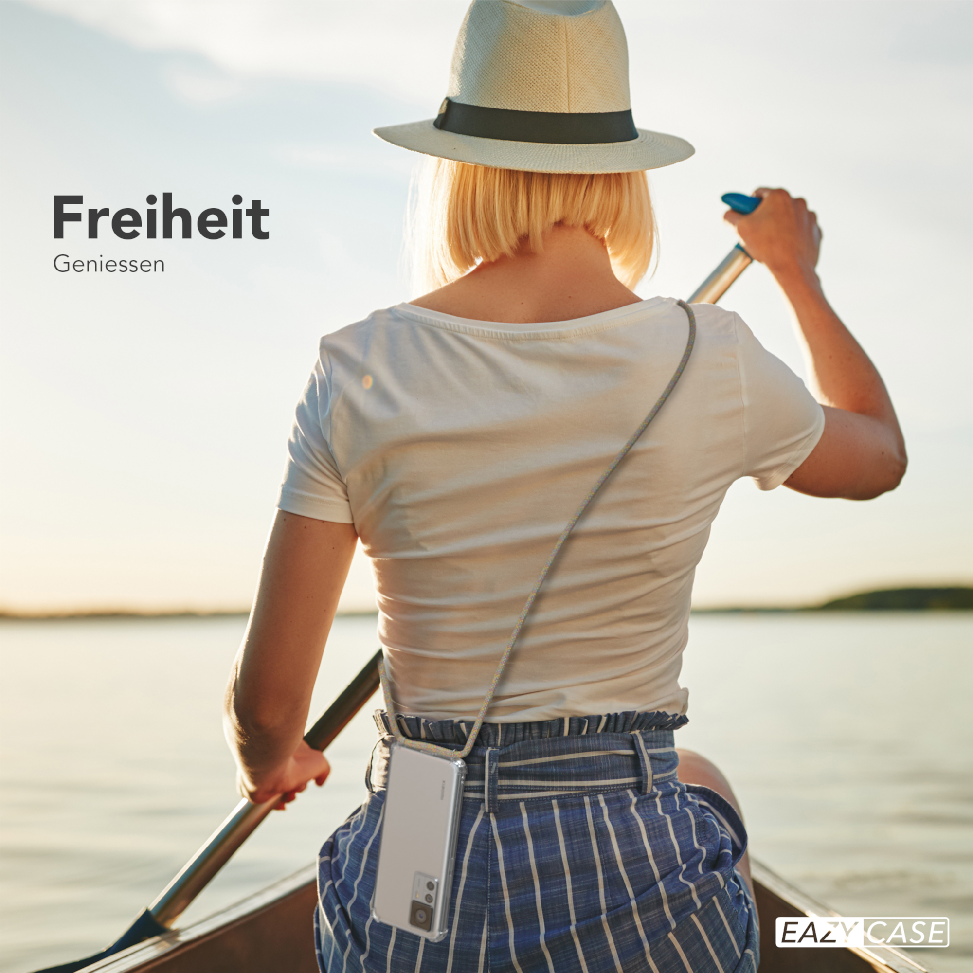 Eine Frau in einem Boot mit einer Handytasche um den Hals. Text oben: Freiheit. Genießen.