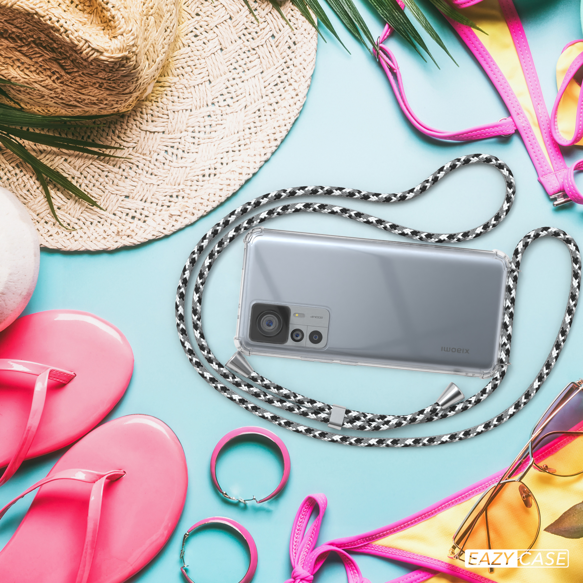 Ein Smartphone in einer transparenten Hülle mit einem schwarz-weißen Lanyard, Strandhintergrund.