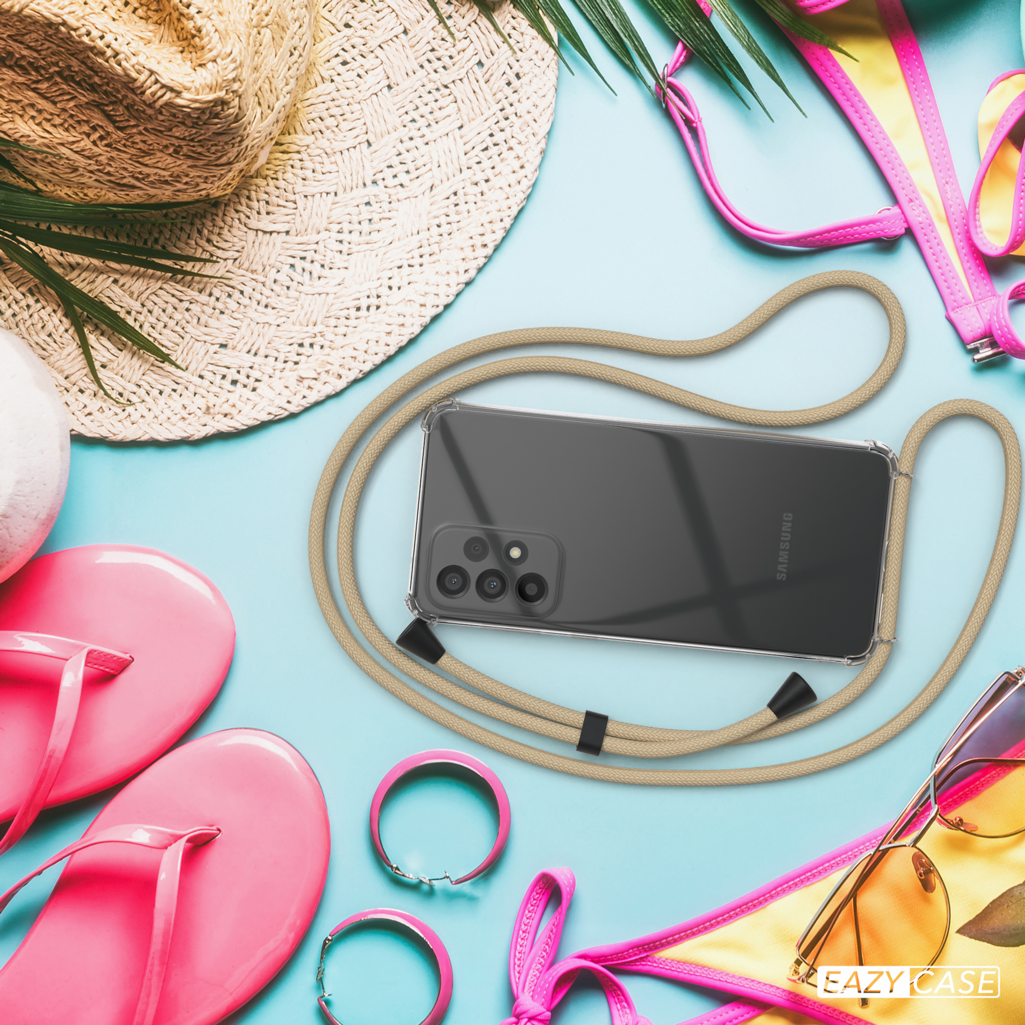 Telefon mit Lanyard, Sonnenbrille und Flip-Flops auf blauer Oberfläche. Bikini-Oberteil im Hintergrund.