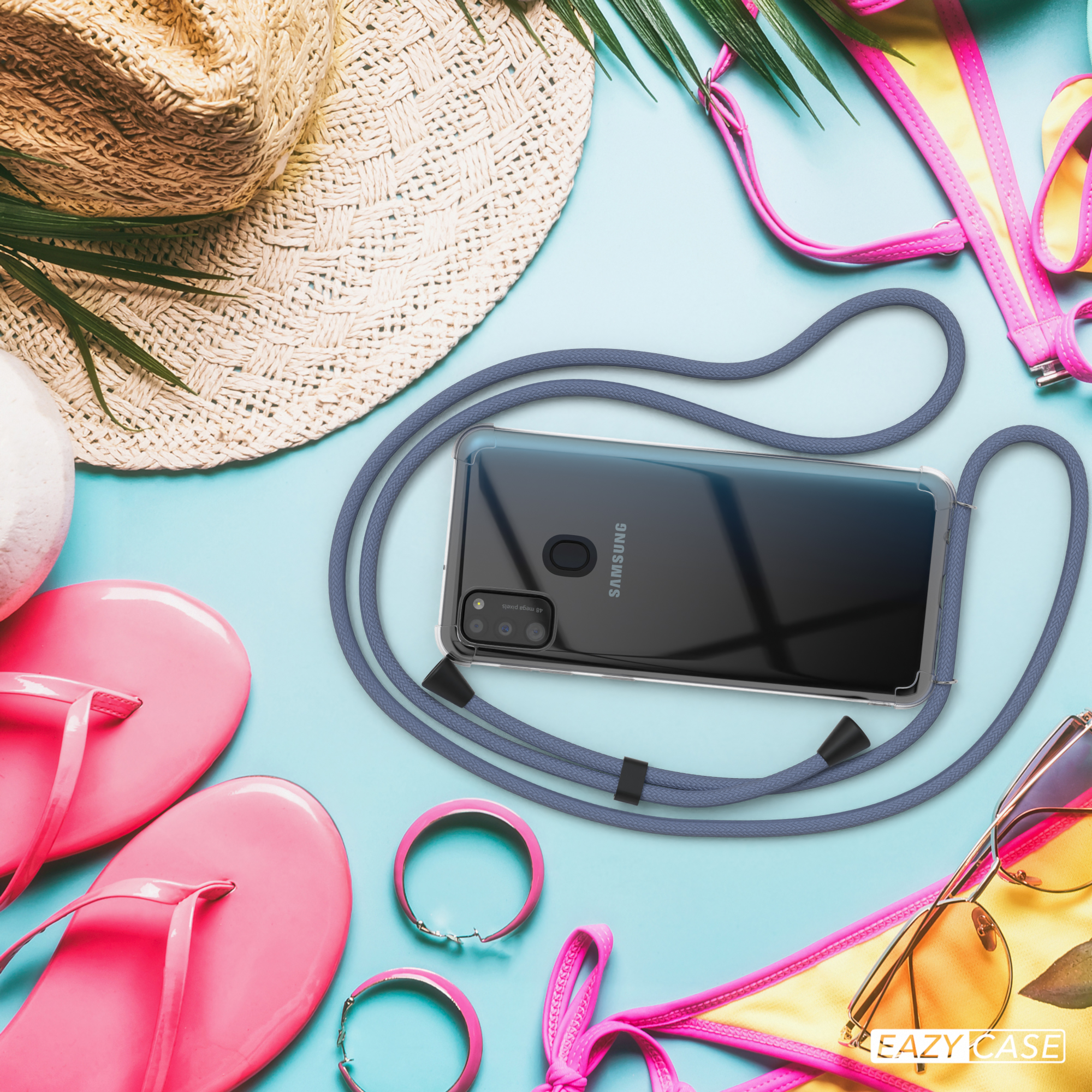 Telefon in einer transparenten Hülle mit Lanyard, umgeben von Strandaccessoires. Text: Eazy Case.