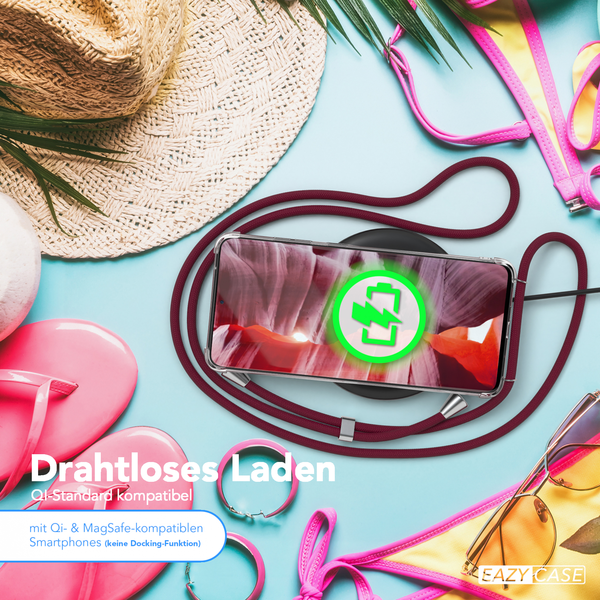 Telefon auf kabellosem Ladegerät, mit Bikini, Sonnenbrille und Accessoires. Hintergrund: blaue Fläche.
