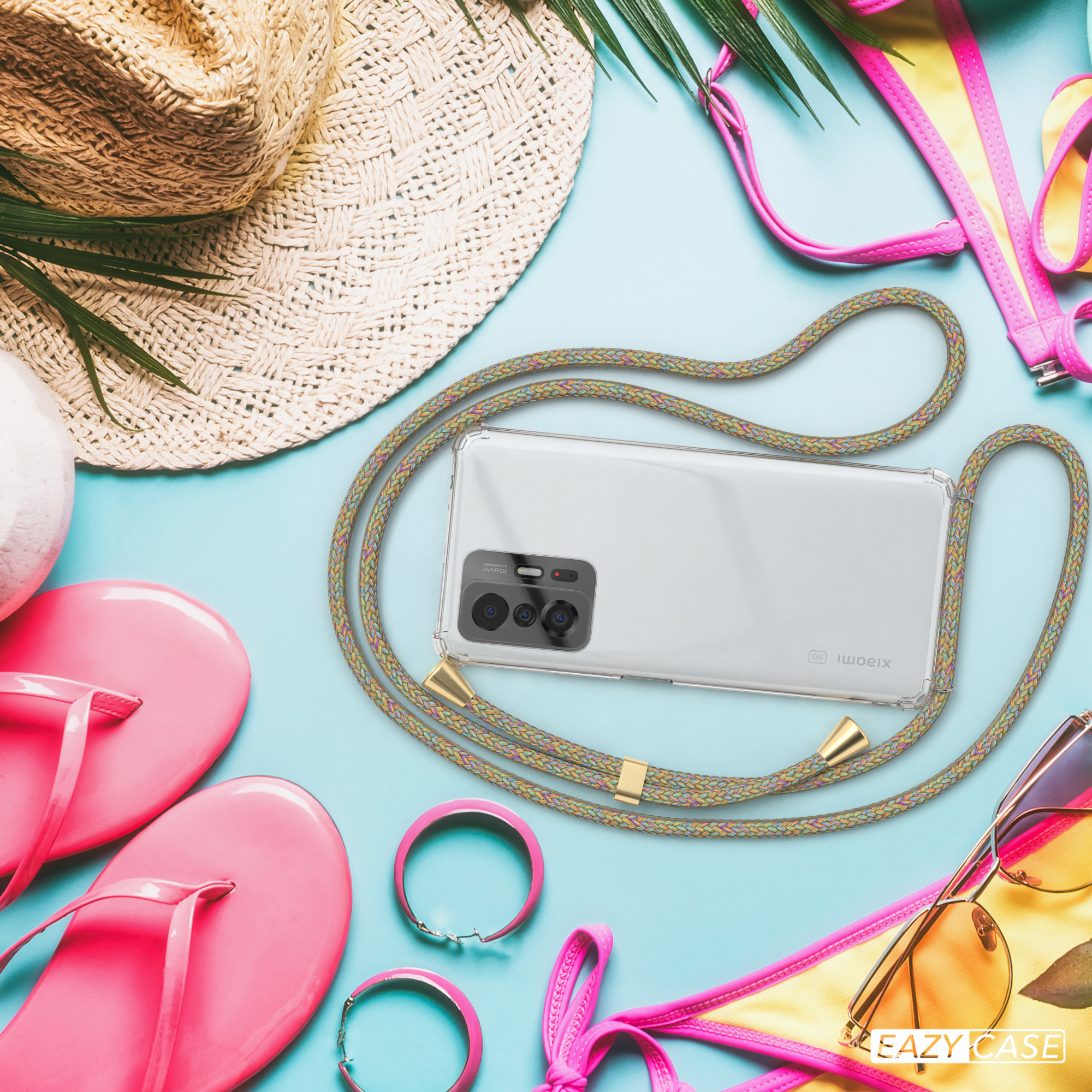 Telefon mit Band, auf Strandaccessoires. Hintergrund: Strandartikel wie Hut und Sonnenbrille.