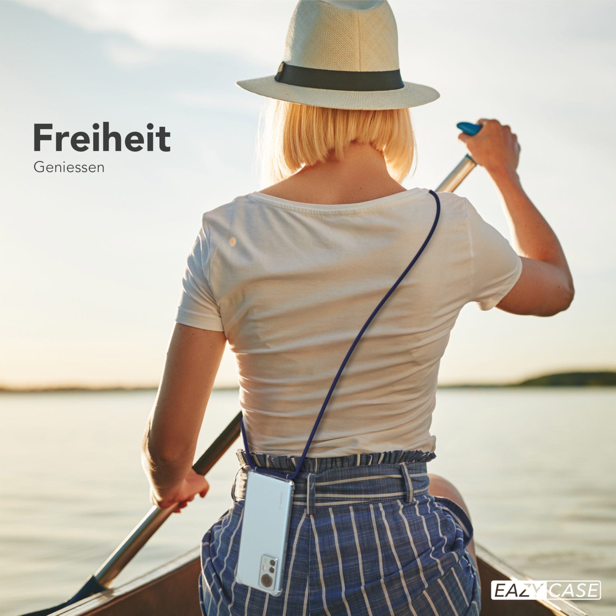 Frau paddelt im Boot. Handyhülle mit marineblauem Gurt. Hut, Sonnenuntergang, Wasser.