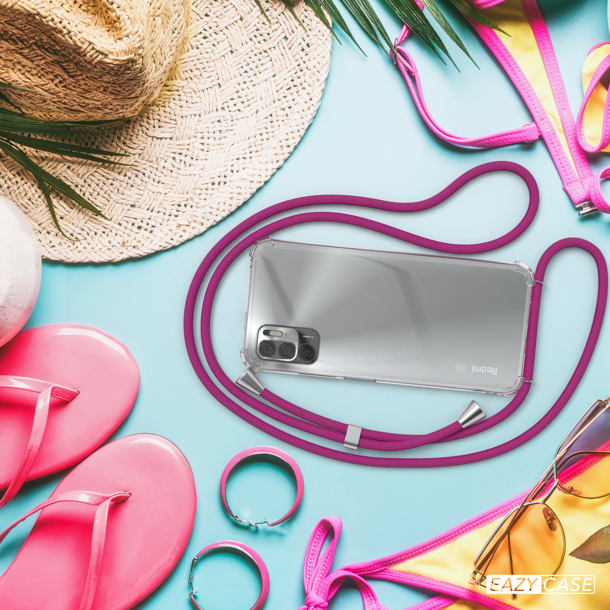 Ein Telefon mit pinkfarbenem Lanyard, Sonnenbrille, Hut und anderem Sommerzubehör auf blauem Untergrund.