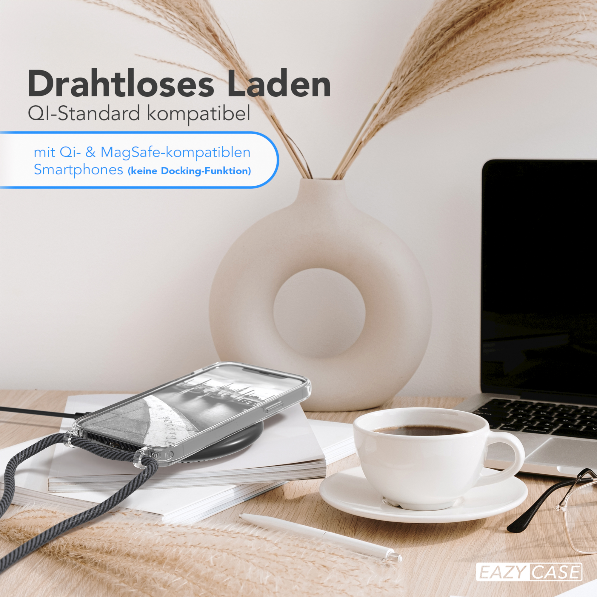 Telefon auf Ladepad auf einem Schreibtisch. Kaffee, Blumen und ein Laptop sind auch vorhanden.
