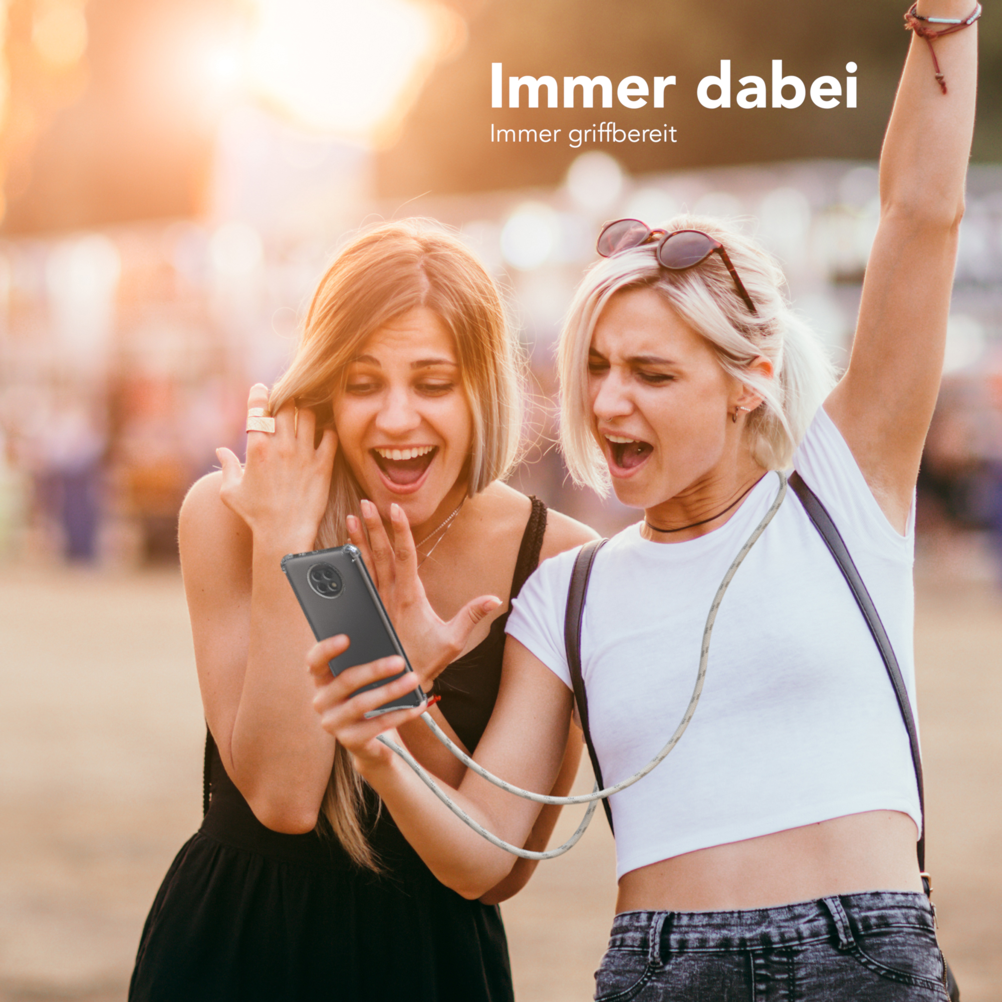 Zwei Frauen schauen aufgeregt auf ein Telefon. Ein Lanyard verbindet das Telefon.