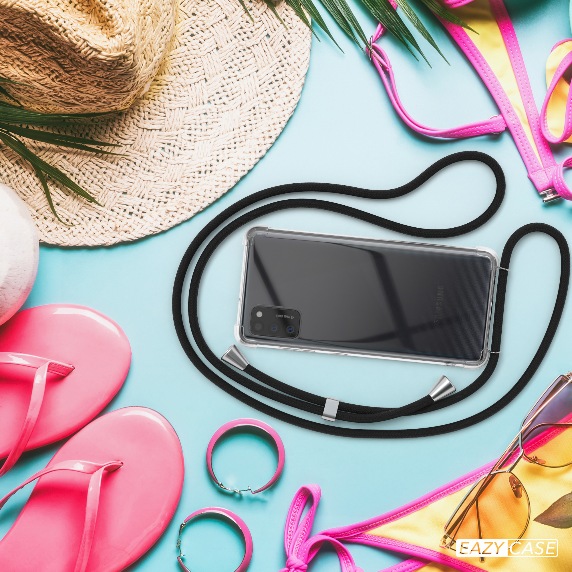 Telefon in Hülle mit Umhängeband, Sonnenbrille, Hut und Accessoires auf blauem Hintergrund.