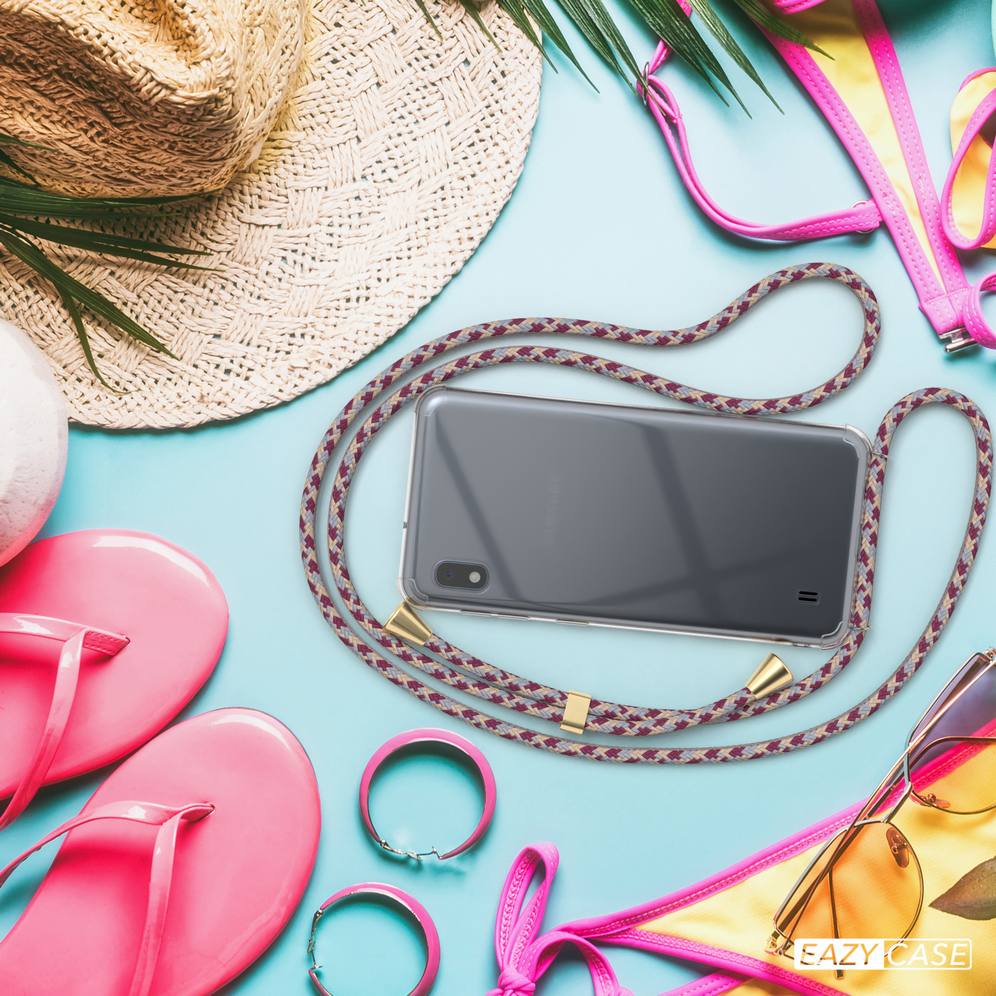 Ein Telefon mit grau-rotem Schlüsselband, Strandaccessoires wie Sonnenbrille und Hut.