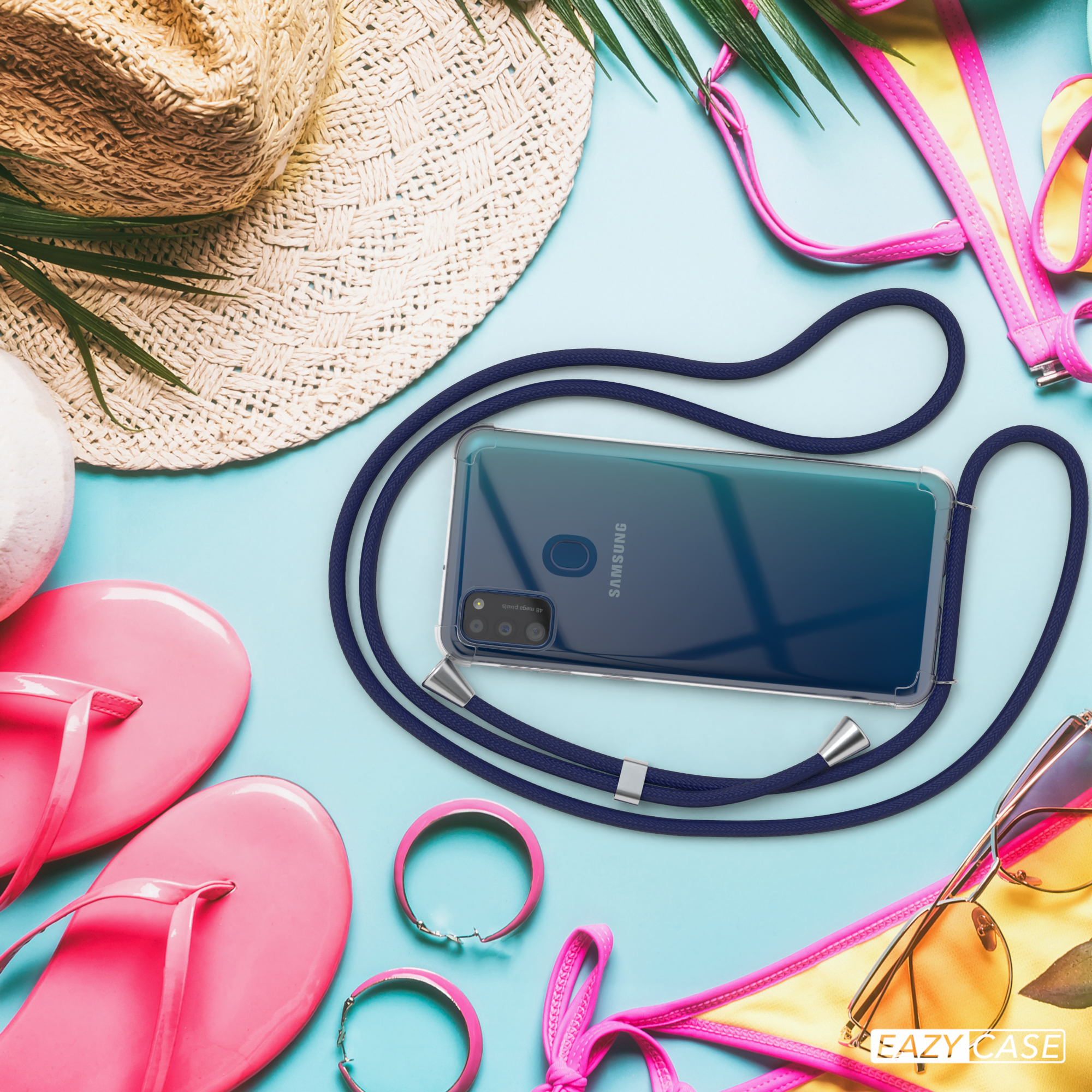 Telefon mit blauem Kabel auf Strand, mit Strohhut und Sonnenbrille.
