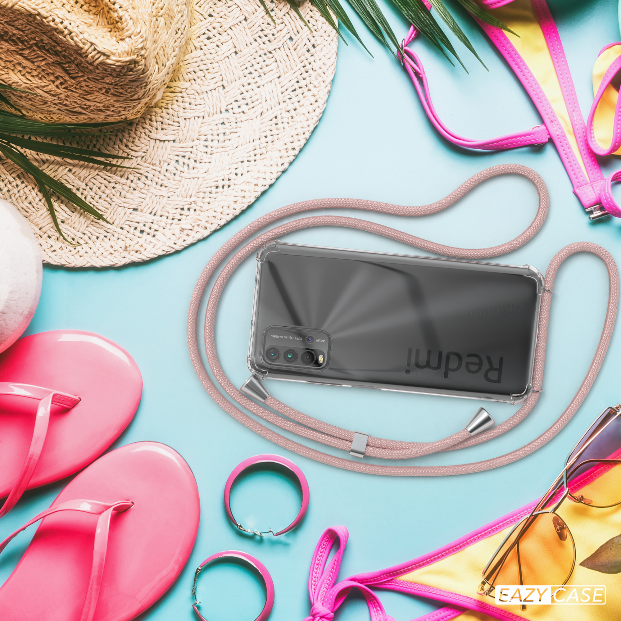 Telefon mit Hülle und Band, Sonnenbrille, Strohhut und Strandaccessoires auf hellblauem Untergrund.