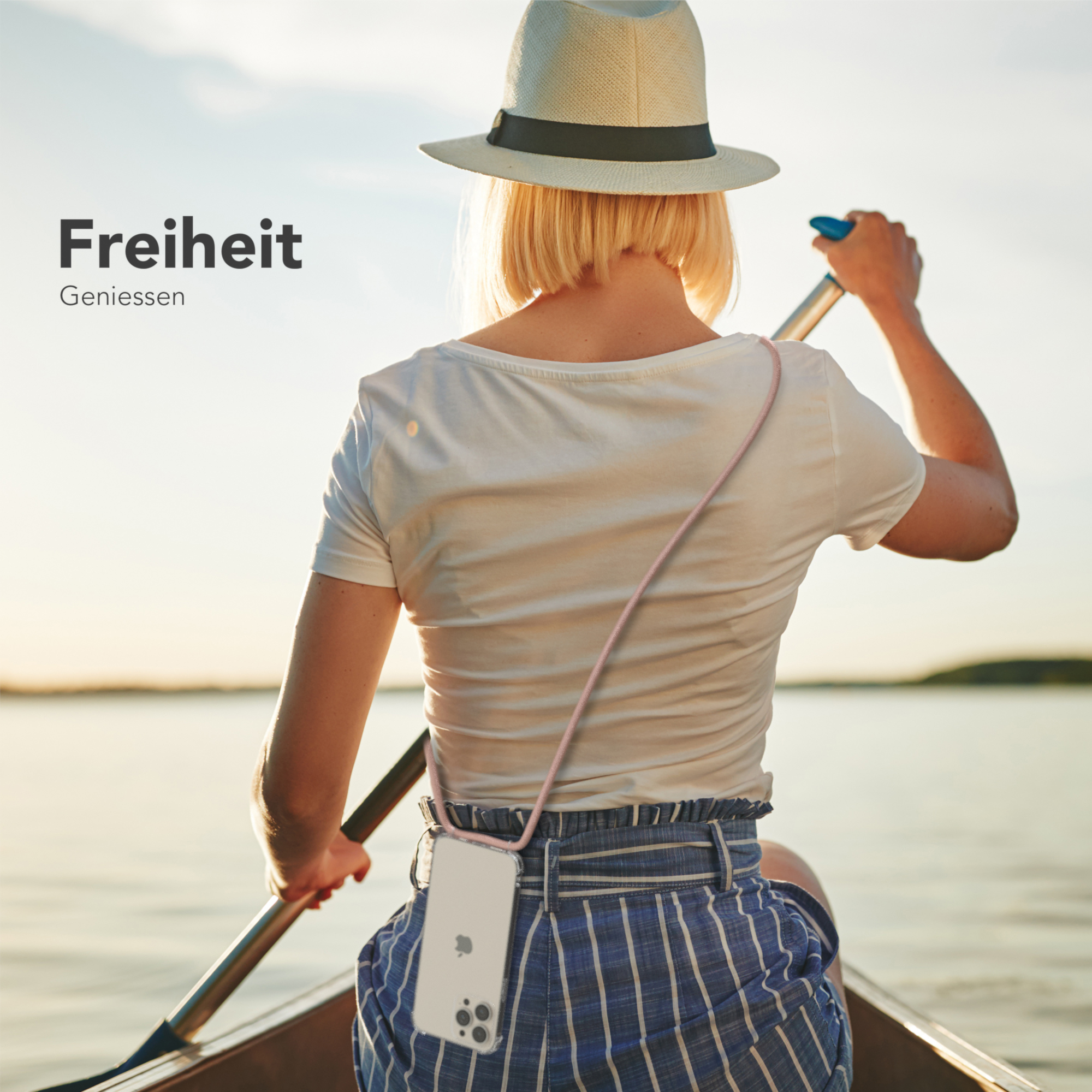 Frau in einem Boot auf dem Wasser, hält ein Ruder mit einer Handyhülle um den Hals.