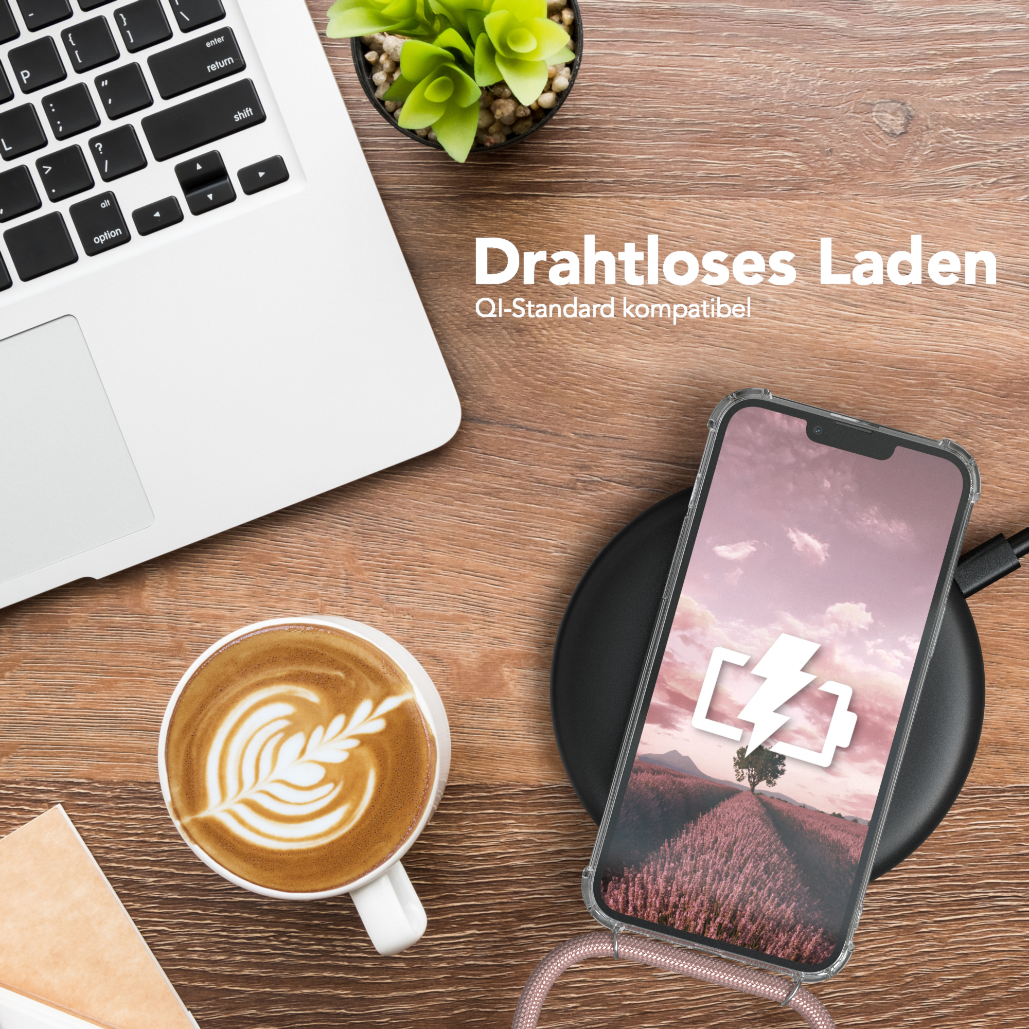 Ein Laptop, Kaffee und Telefon auf einem Holztisch. Das Telefon wird geladen. Ein Baum-Bild auf dem Bildschirm.