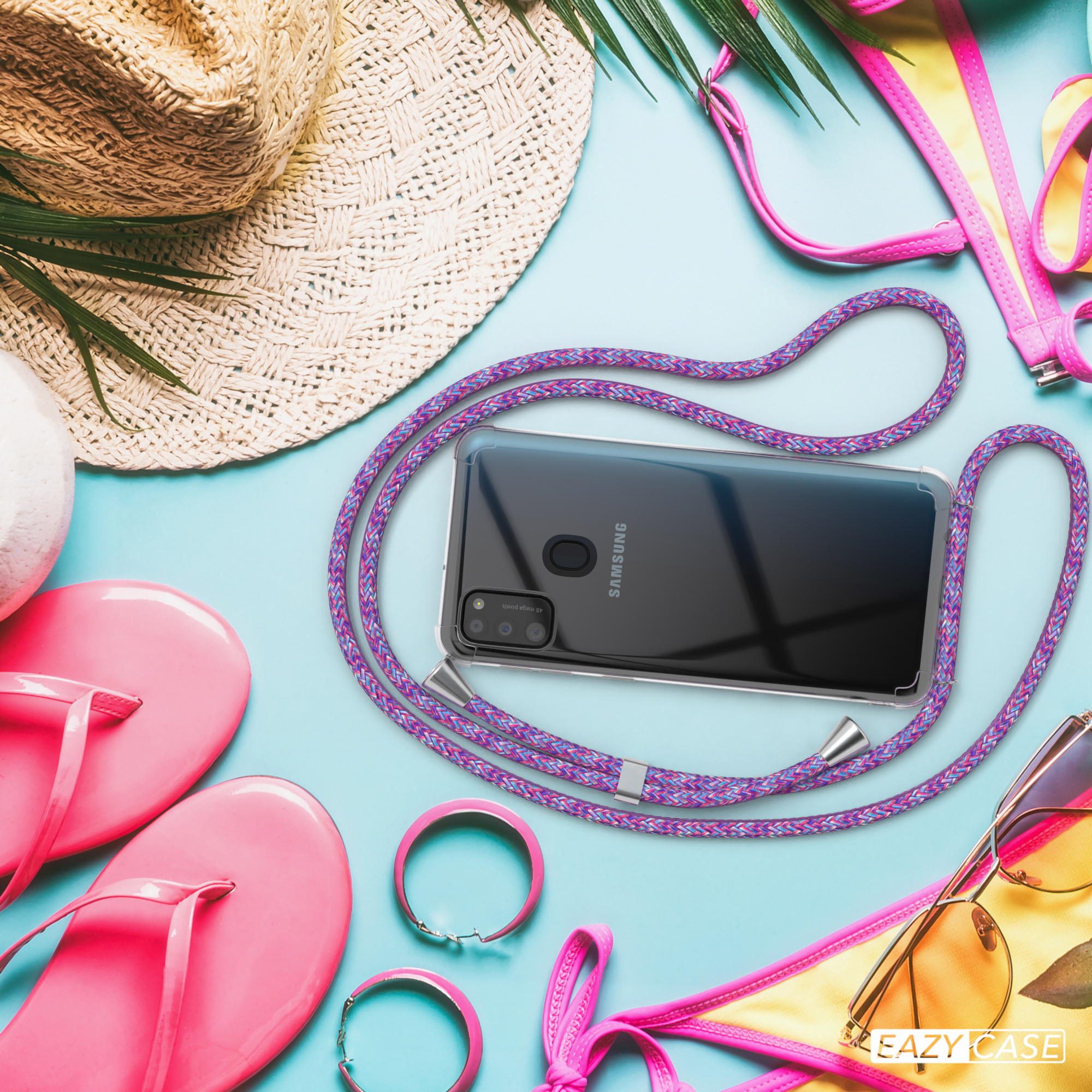 Strandszene: Handy mit Hülle und lila Lanyard, Flip-Flops, Sonnenbrille, Bikini. Text: Kabelloses Laden.
