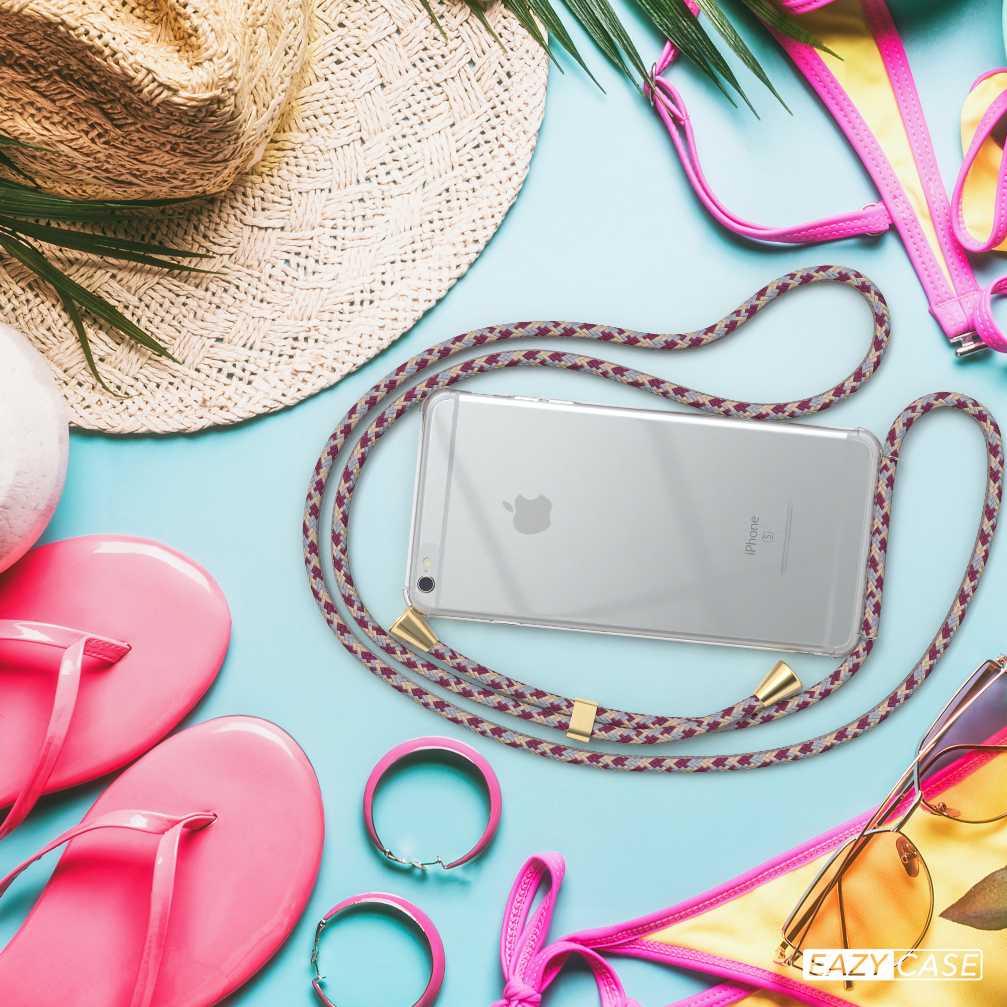 Telefon mit klarer Hülle und einem rot/grauen Lanyard auf blauem Untergrund, mit Strandartikeln wie Hut und Sonnenbrille.