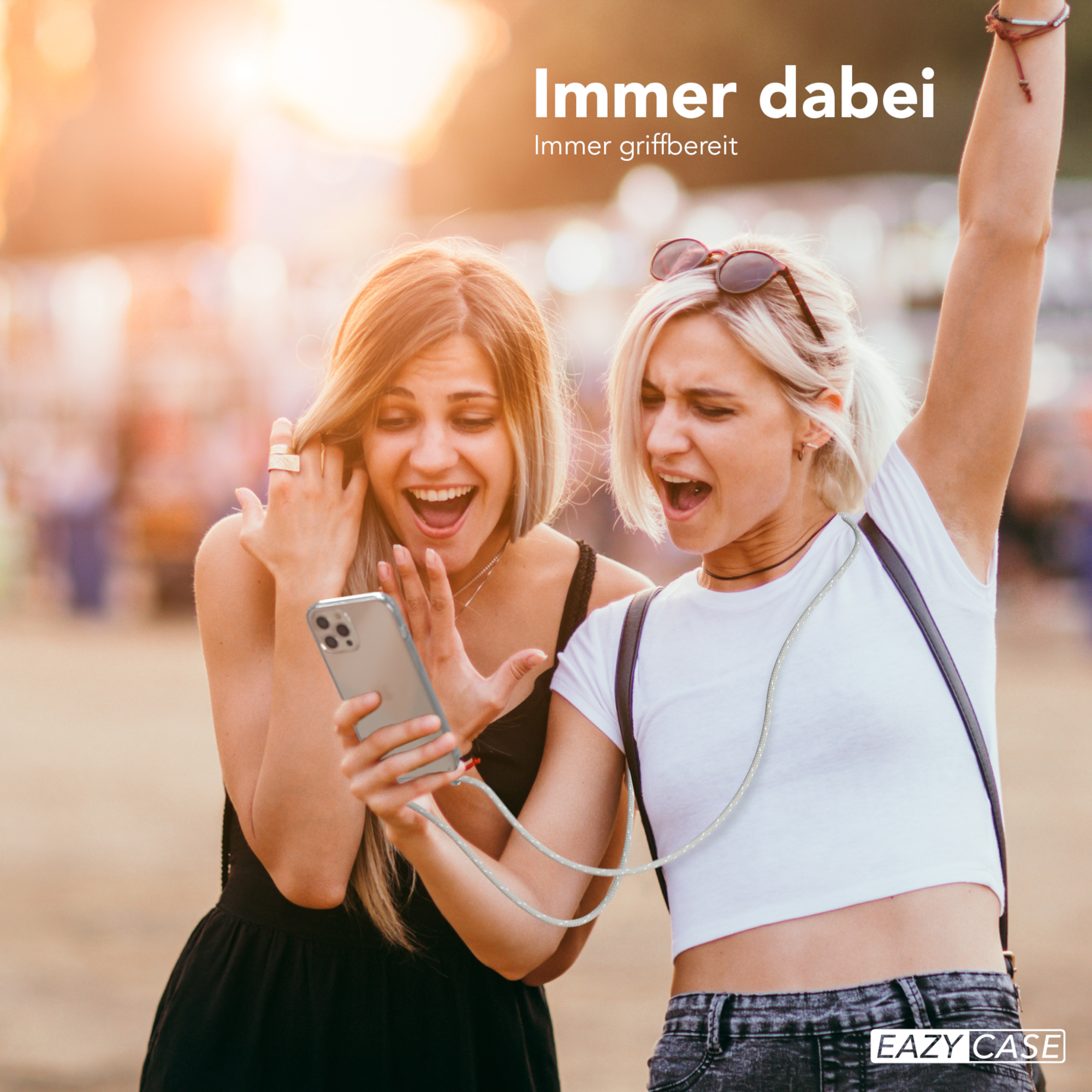 Zwei Frauen schauen auf ein Telefon. Eine hält es, die andere hebt den Arm. Text: 'Immer dabei'.