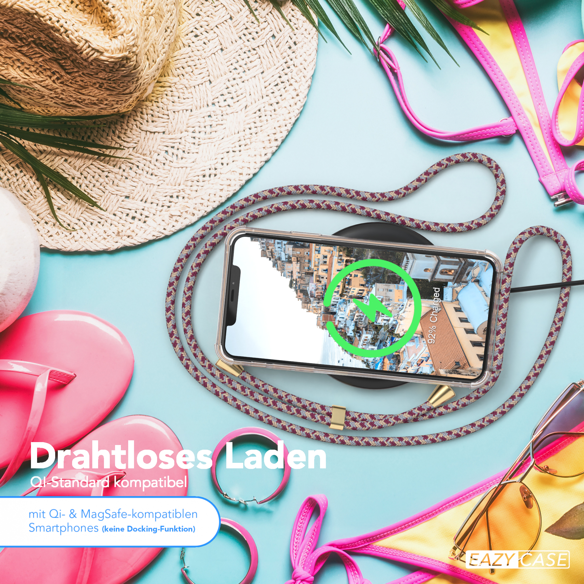 Telefon wird kabellos geladen, am Strand. Flip-Flops, Sonnenbrille und Hut sichtbar.