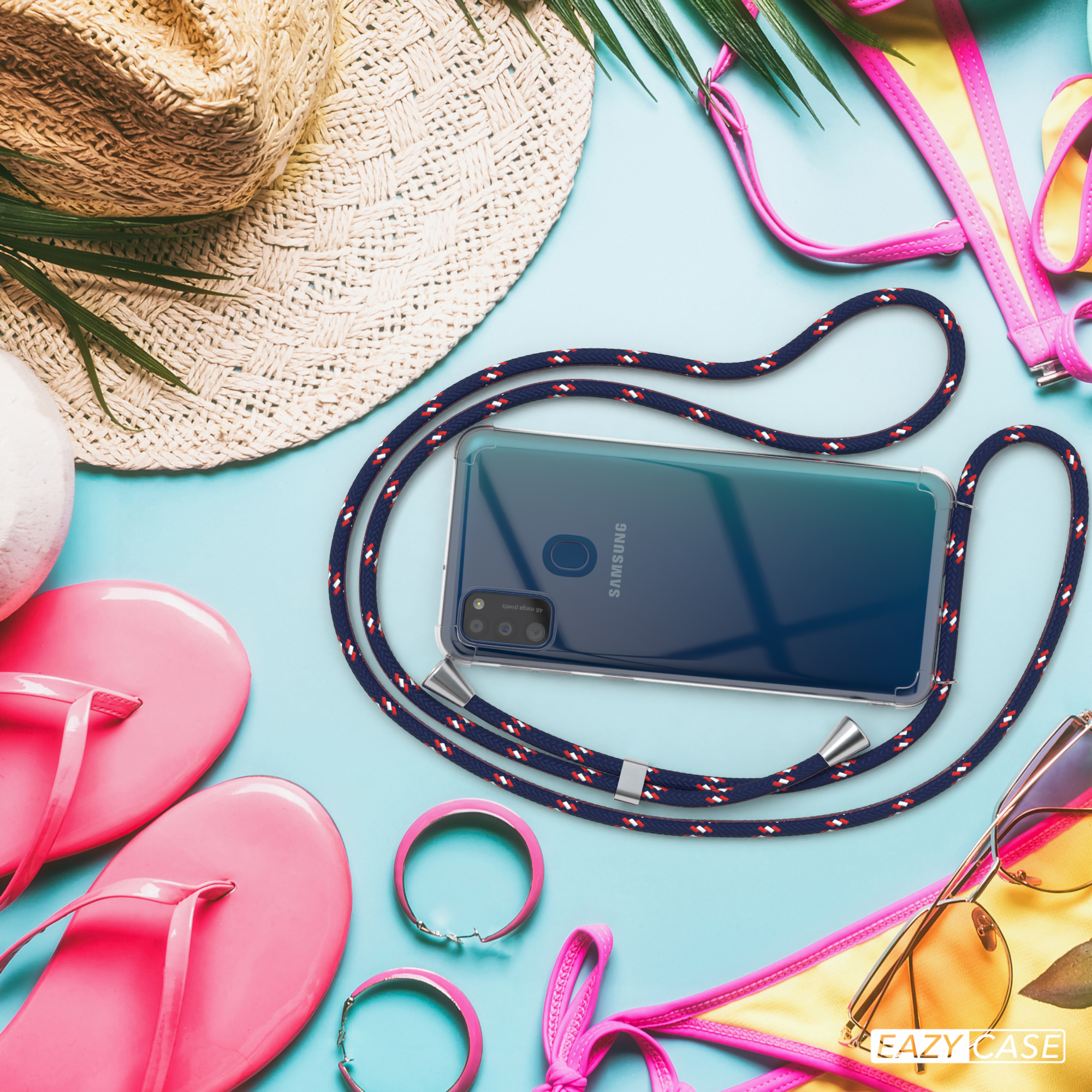 Telefon und Lanyard am Strand. Sonnenbrille, Flip-Flops und Strohhut sind vorhanden.