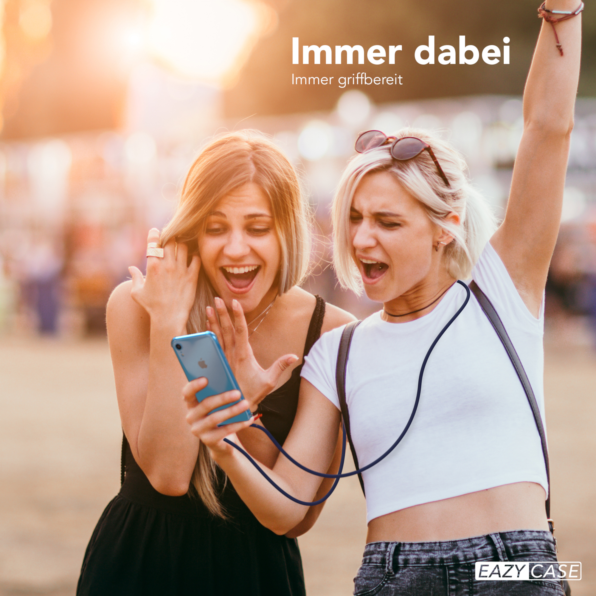 Zwei Frauen schauen auf ein Telefon, mit Kabel, im Freien.