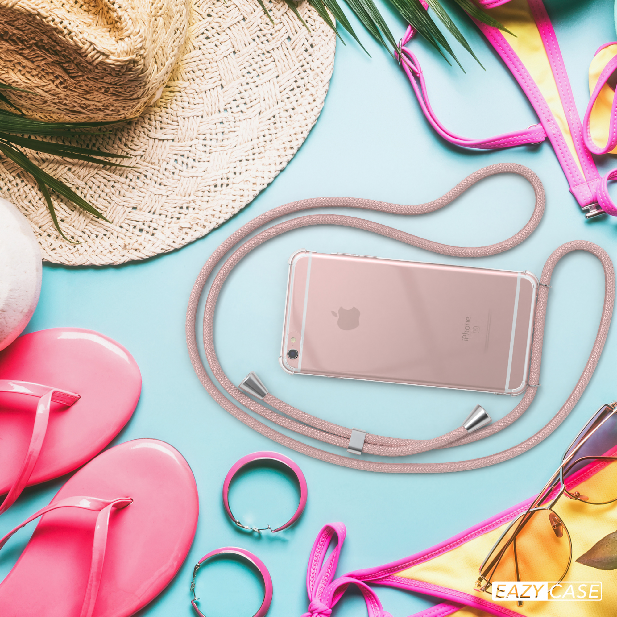 Telefon mit rosa Kabel auf Strand, mit Strohhut und Sonnenbrille.