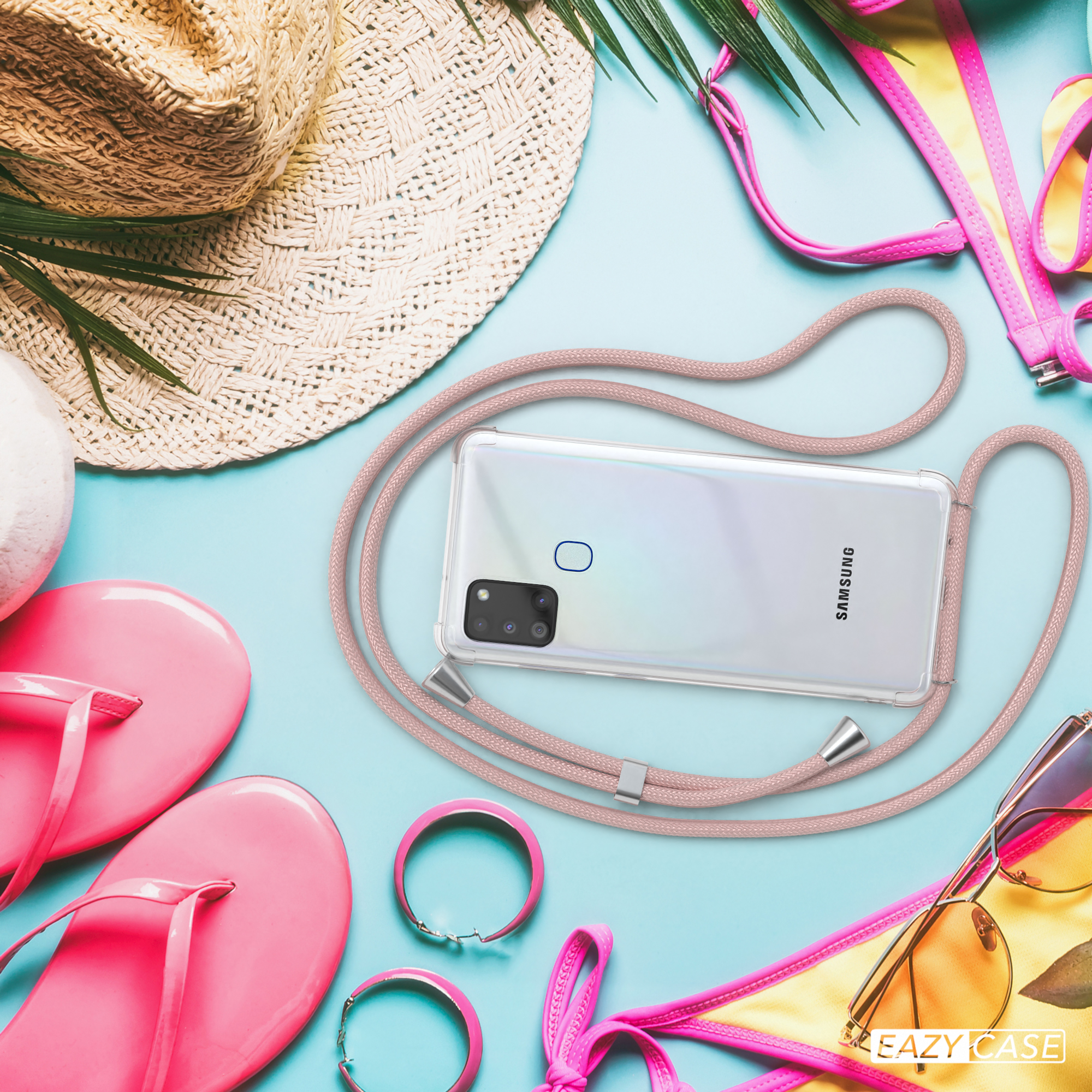 Telefon mit Hülle am Strand mit Zubehör, in der Nähe eines Strohhutes und Flip-Flops.