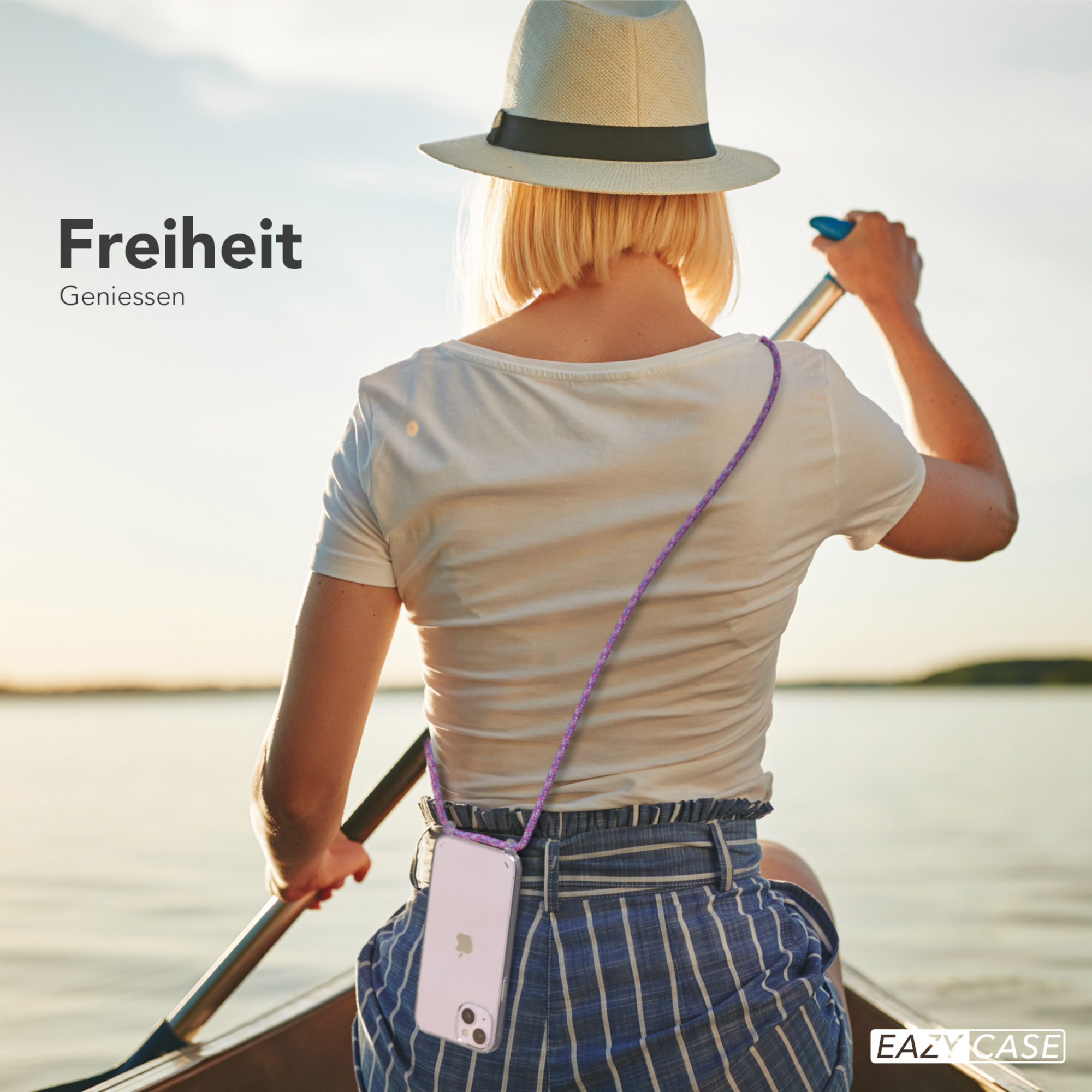 Frau im Hut rudert auf einem See. Ein Telefon hängt an ihrem Hals.