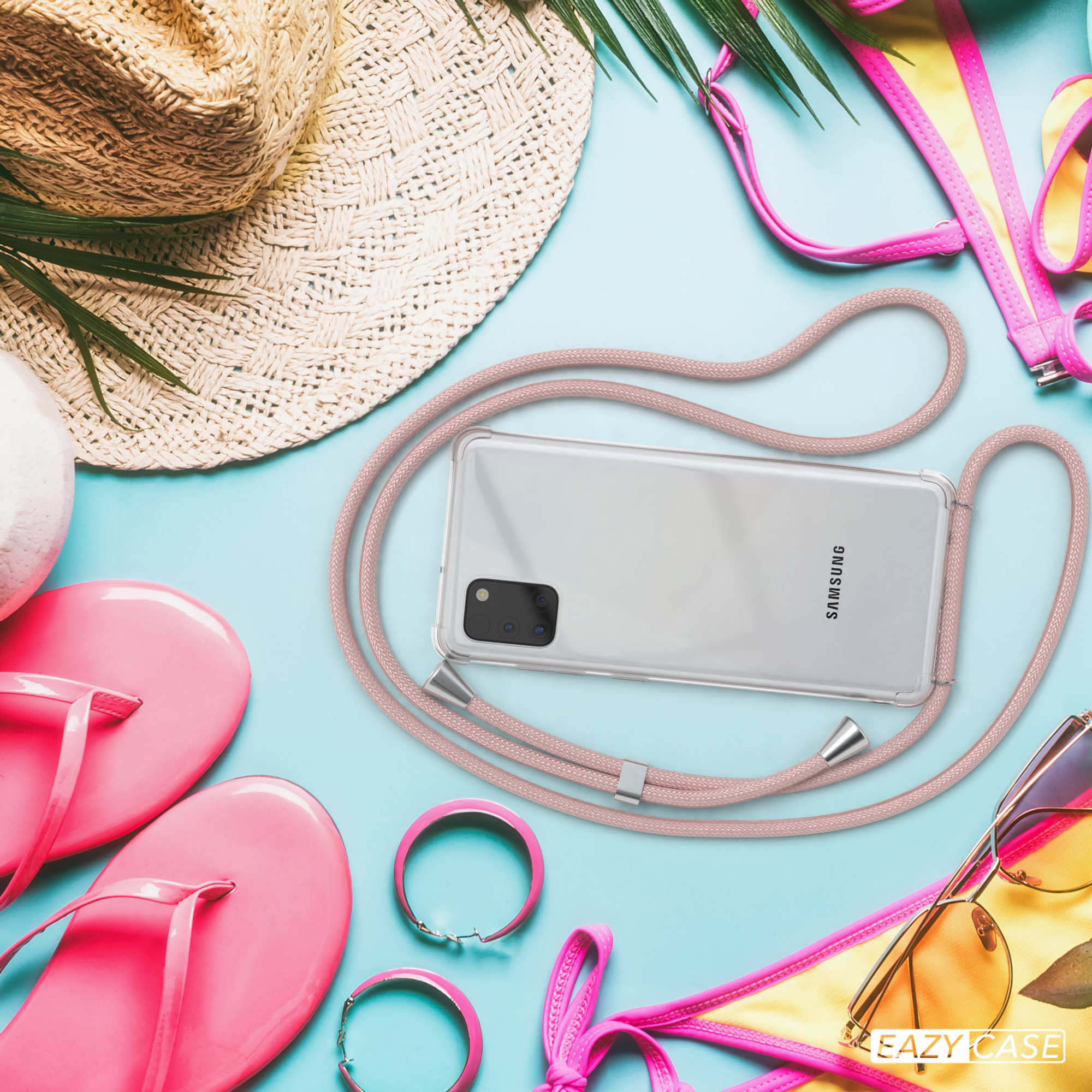 Ein Telefon in einer Hülle, mit pinkfarbenem Riemen, Sonnenzubehör und blauem Hintergrund.