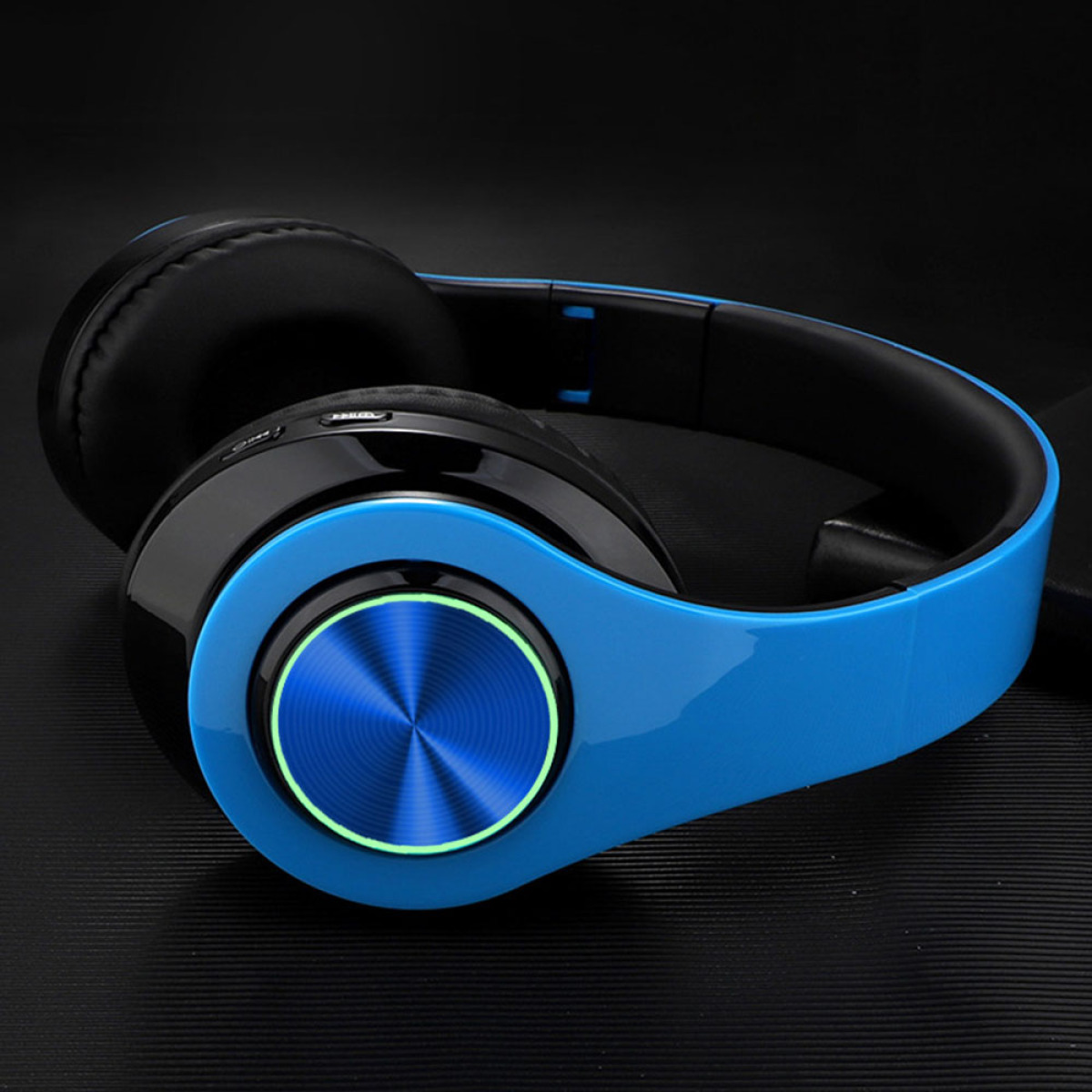 Nahaufnahme von blauen und schwarzen Kopfhörern. Die Ohrmuscheln sind schwarz, das Kopfband blau.