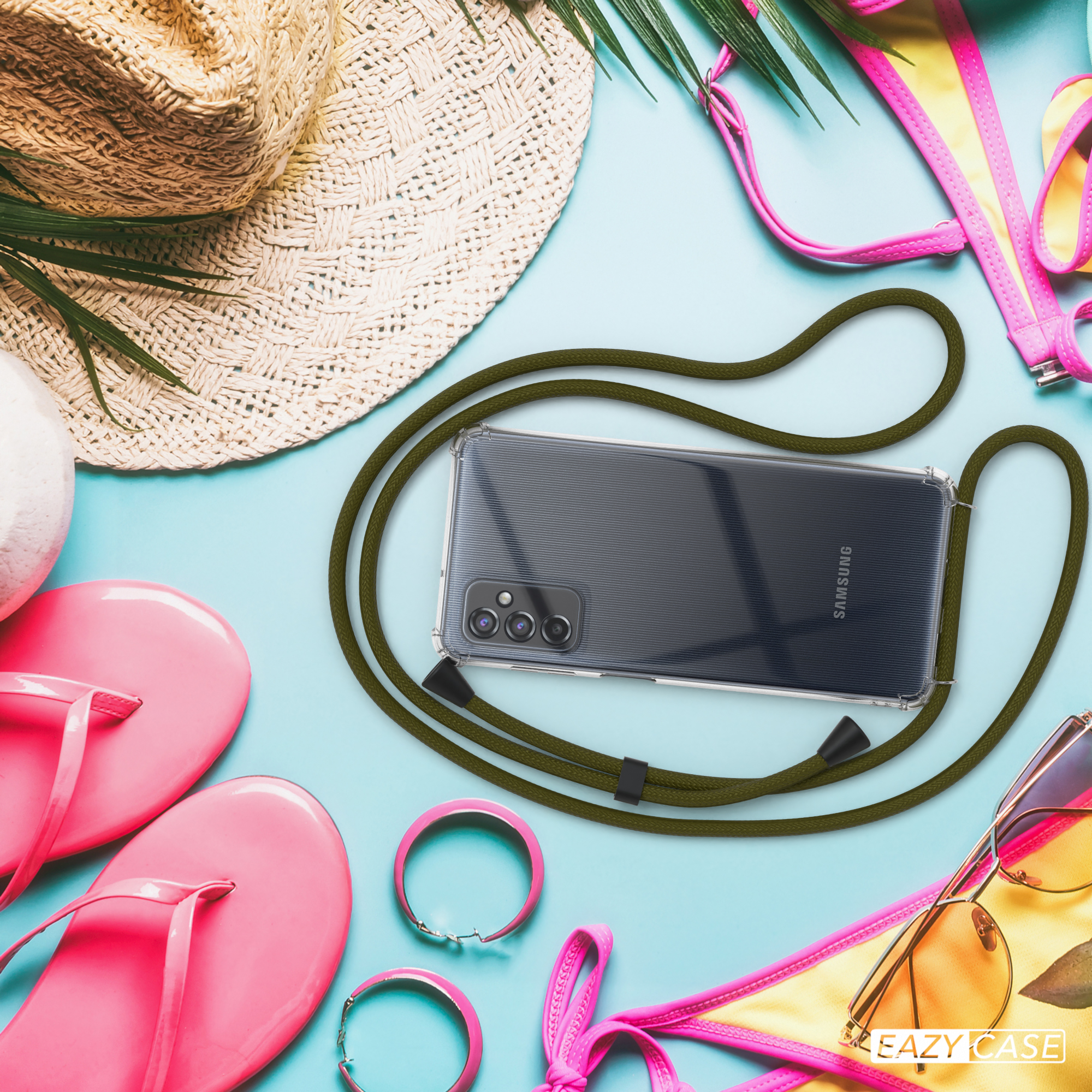 Telefon in einer Hülle mit grünem Band. Strandaccessoires drumherum. Der Hintergrund ist blau und gelb.