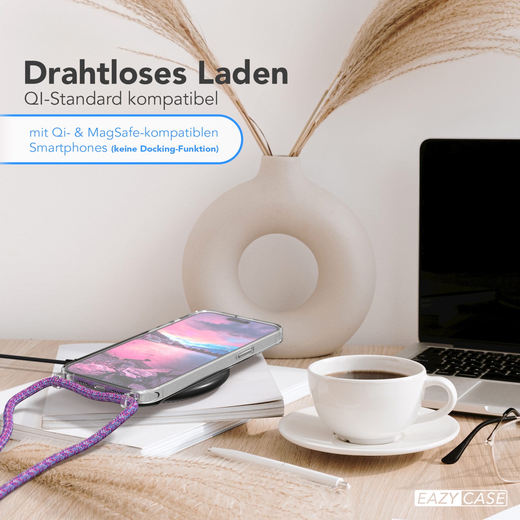 Telefon auf kabellosem Ladegerät auf Schreibtisch. Hintergrund: Kaffeetasse, Laptop und Vase.