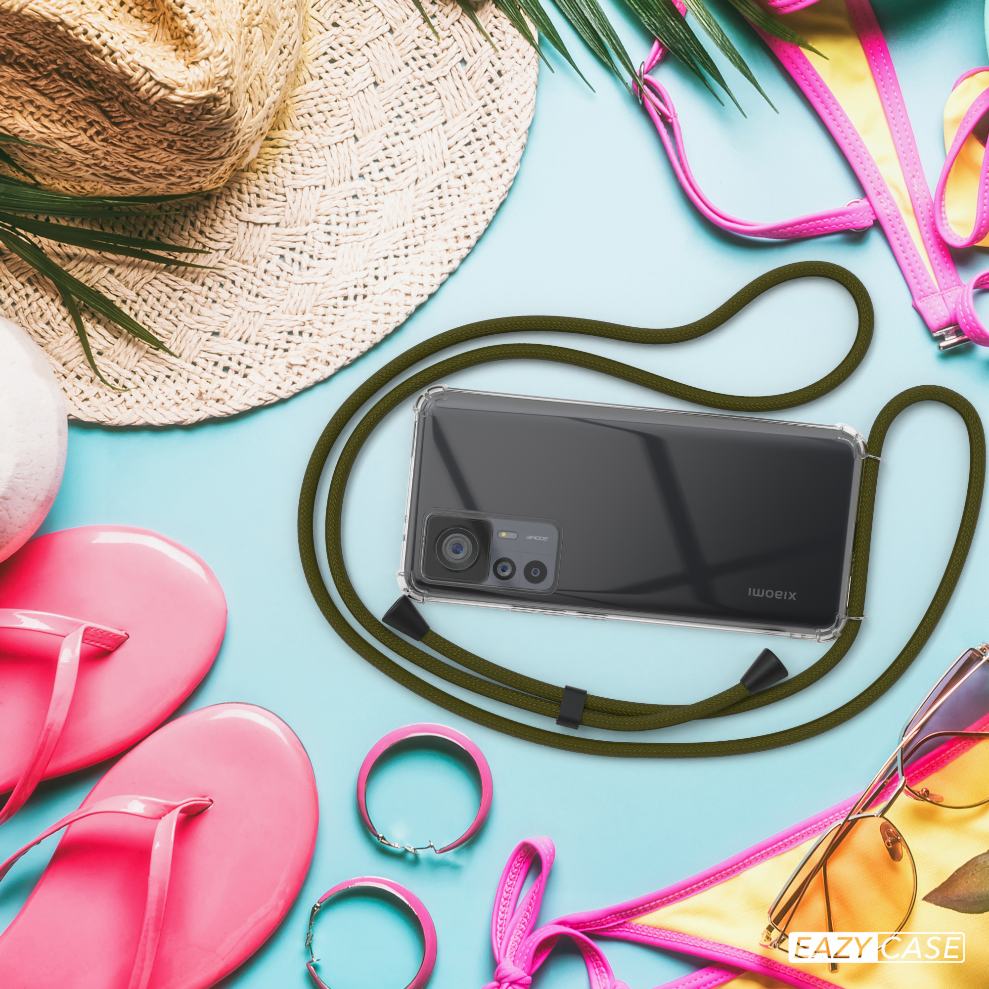Telefon mit Hülle und Lanyard auf blauem Untergrund, mit Strandzubehör: Hut, Sandalen, Sonnenbrille.