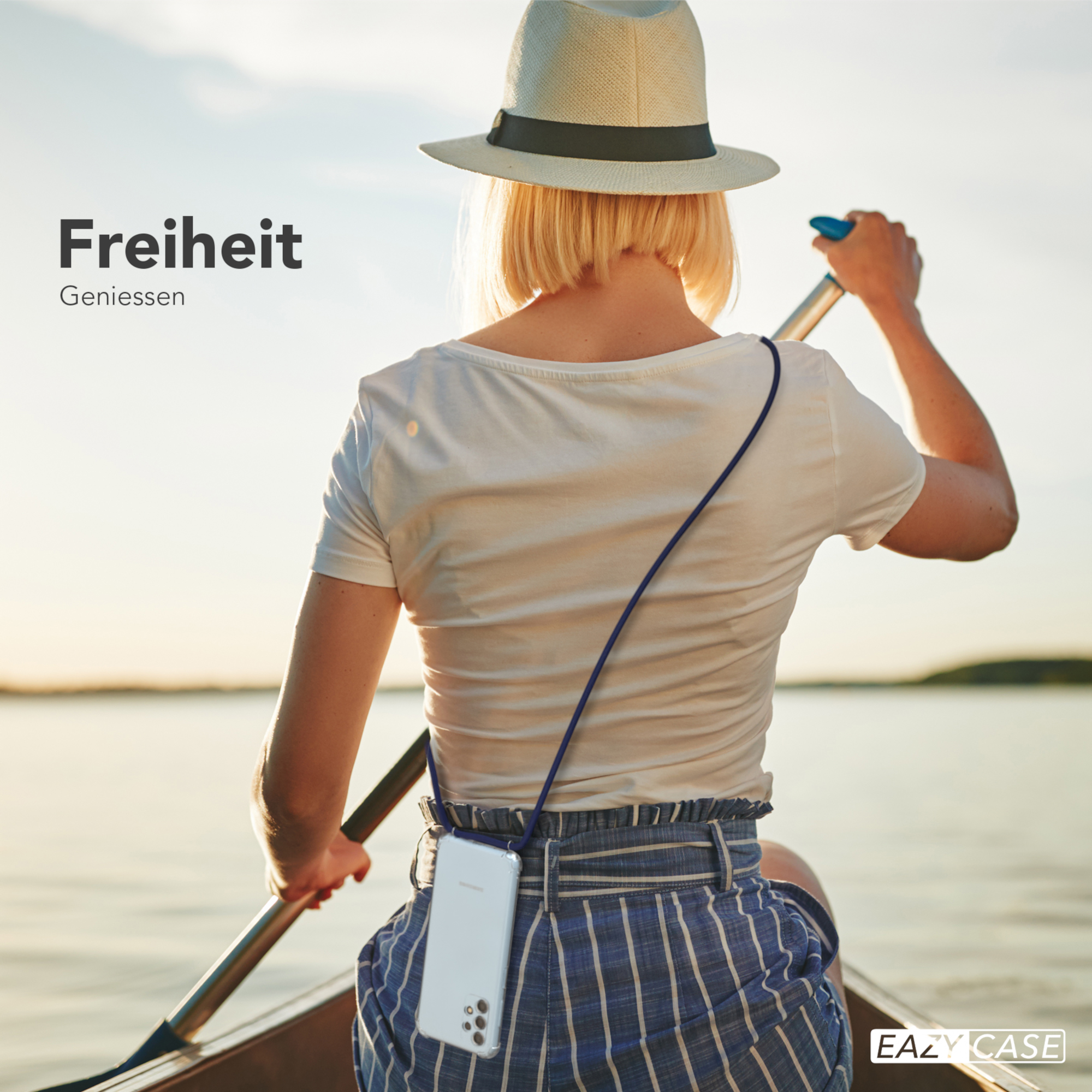 Frau im Boot, Ruder haltend, trägt Hut und Handyhülle mit marineblauem Riemen. See im Hintergrund.