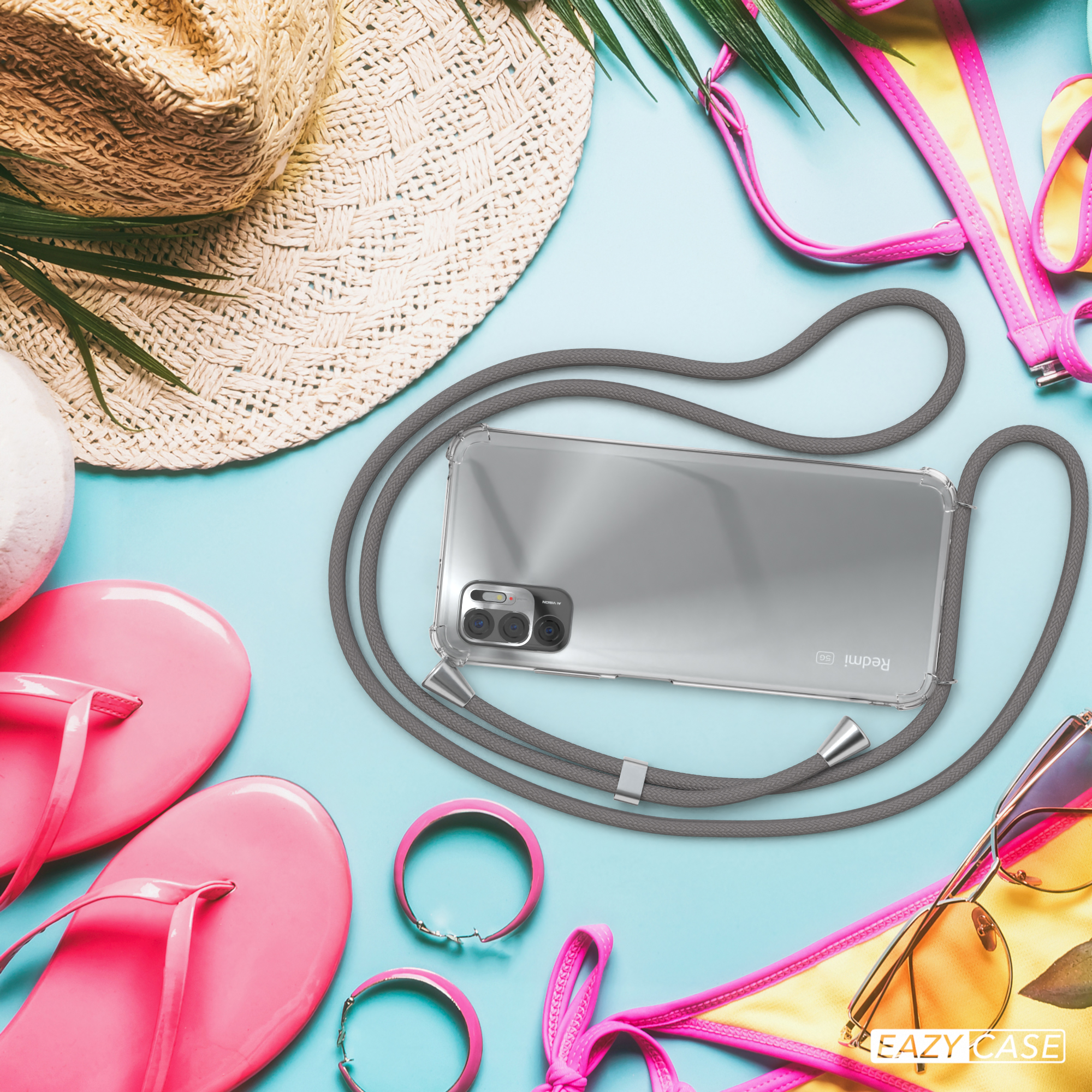 Strandszene mit Handy in Hülle, Strohhut, rosa Flip-Flops und gelbem Bikini-Oberteil.