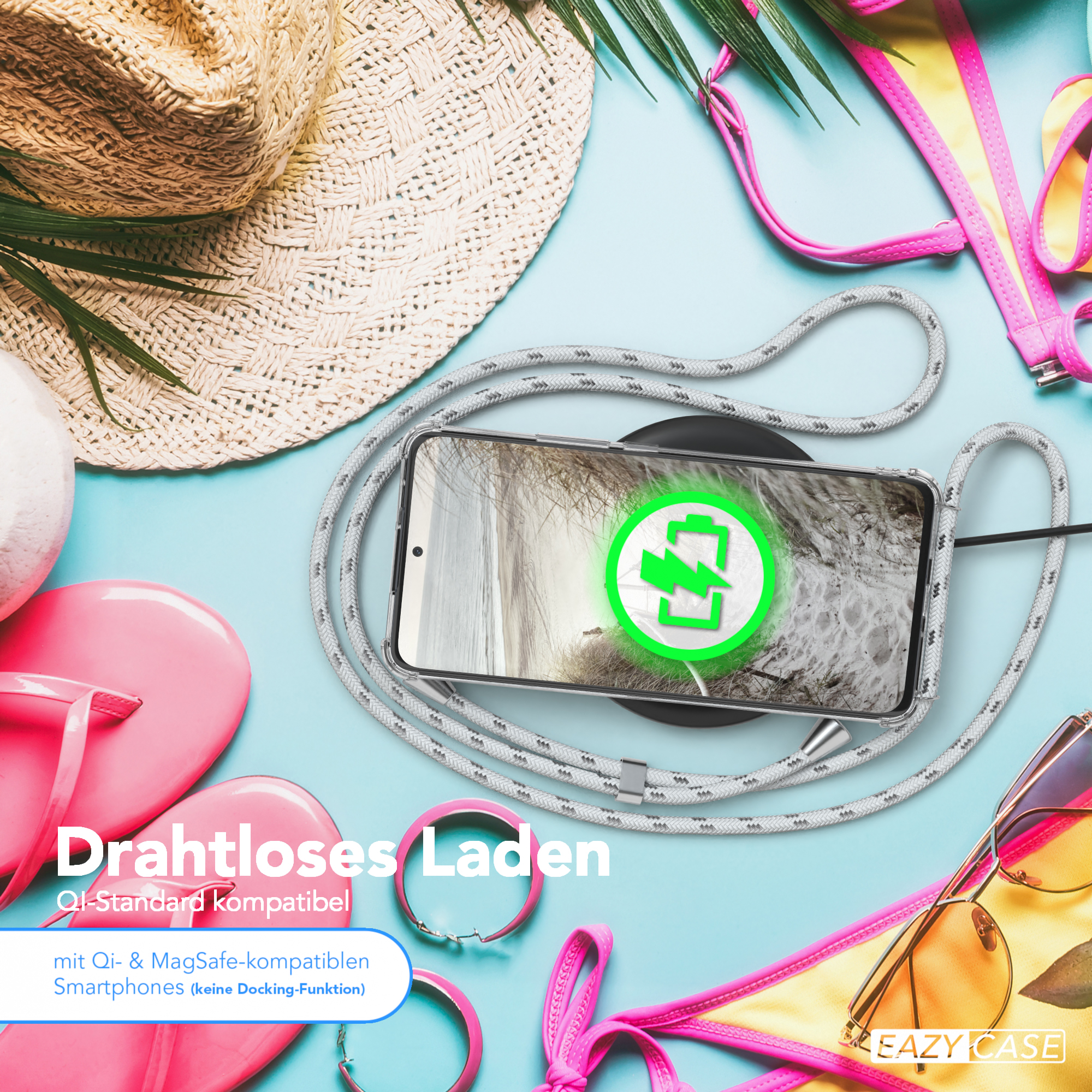 Telefon mit Ladegerät auf Strandmotiv mit Hut, Sonnenbrille und rosa Accessoires.