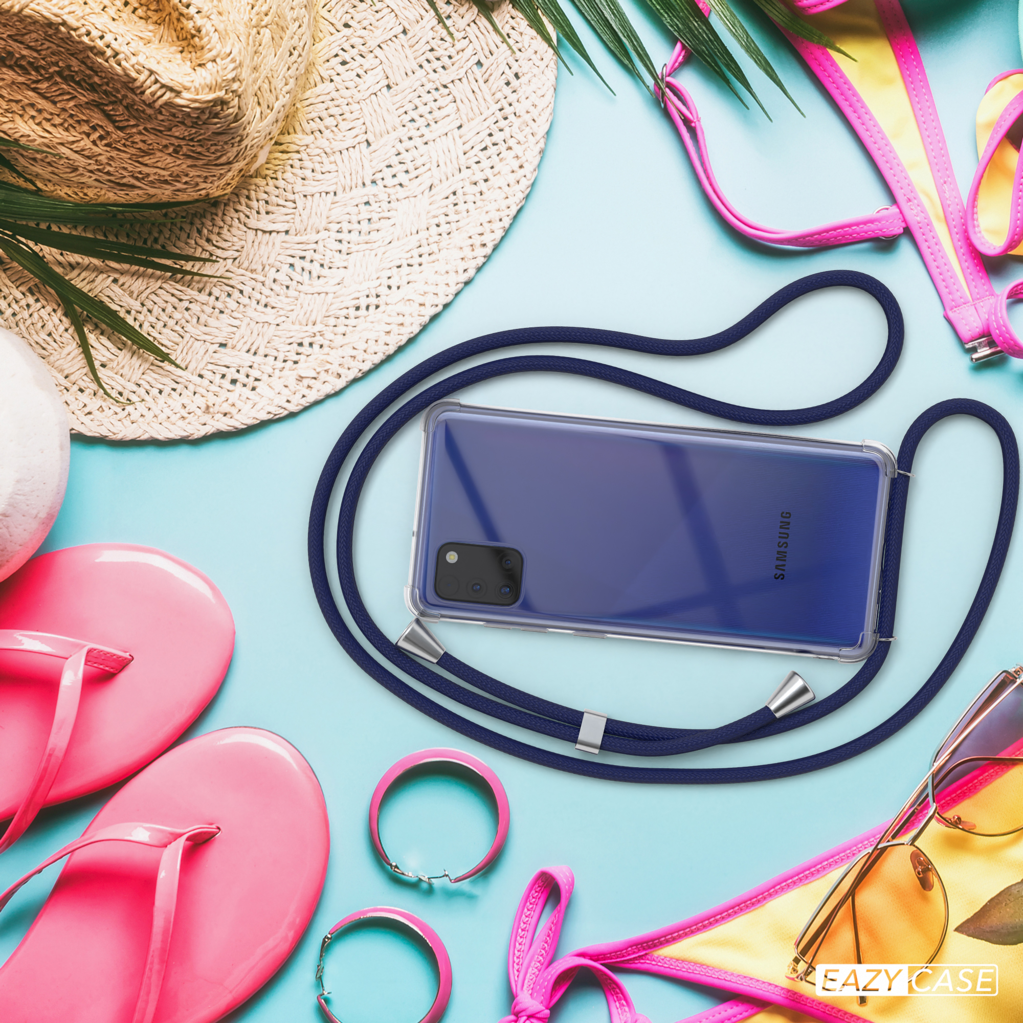 Telefon mit Lanyard auf blauem Untergrund mit Strandutensilien: Hut, Sonnenbrille, rosa Flip-Flops und Zubehör.