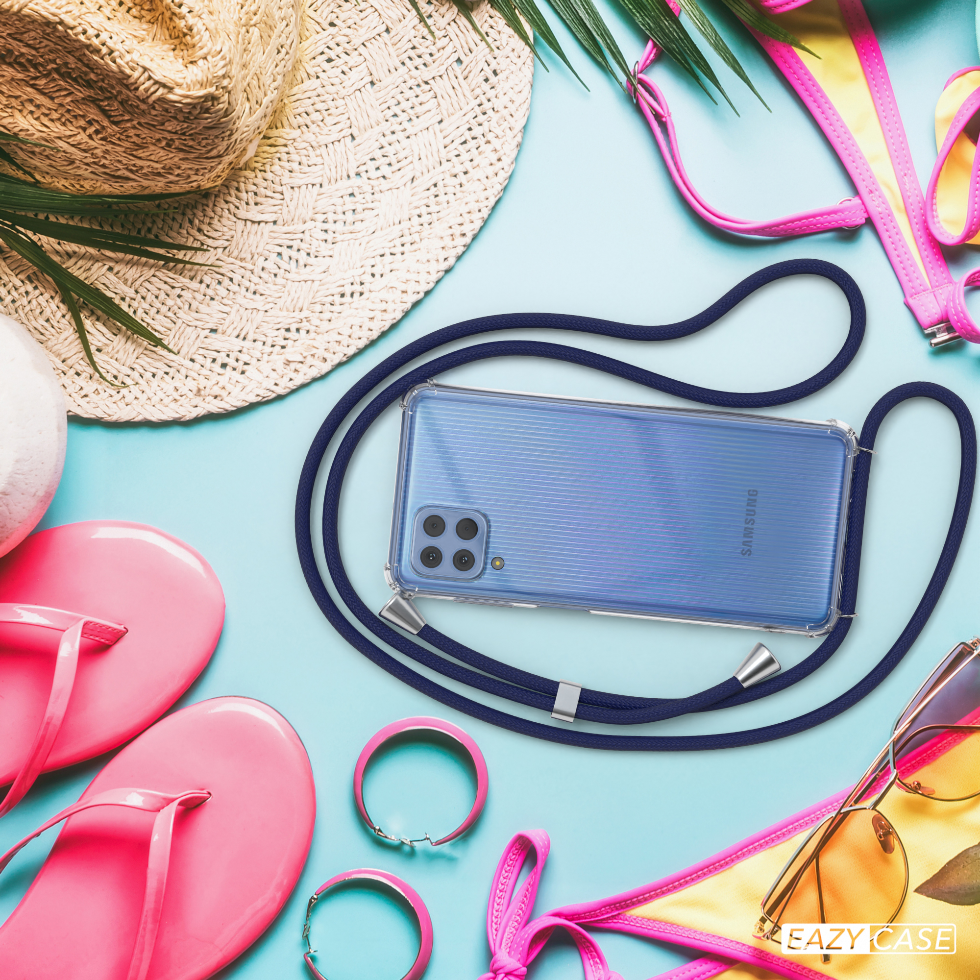 Handyhülle mit blauem Kordel, Sonnenbrille, Strohhut, rosa Flip-Flops und Schmuck auf blauem Untergrund.