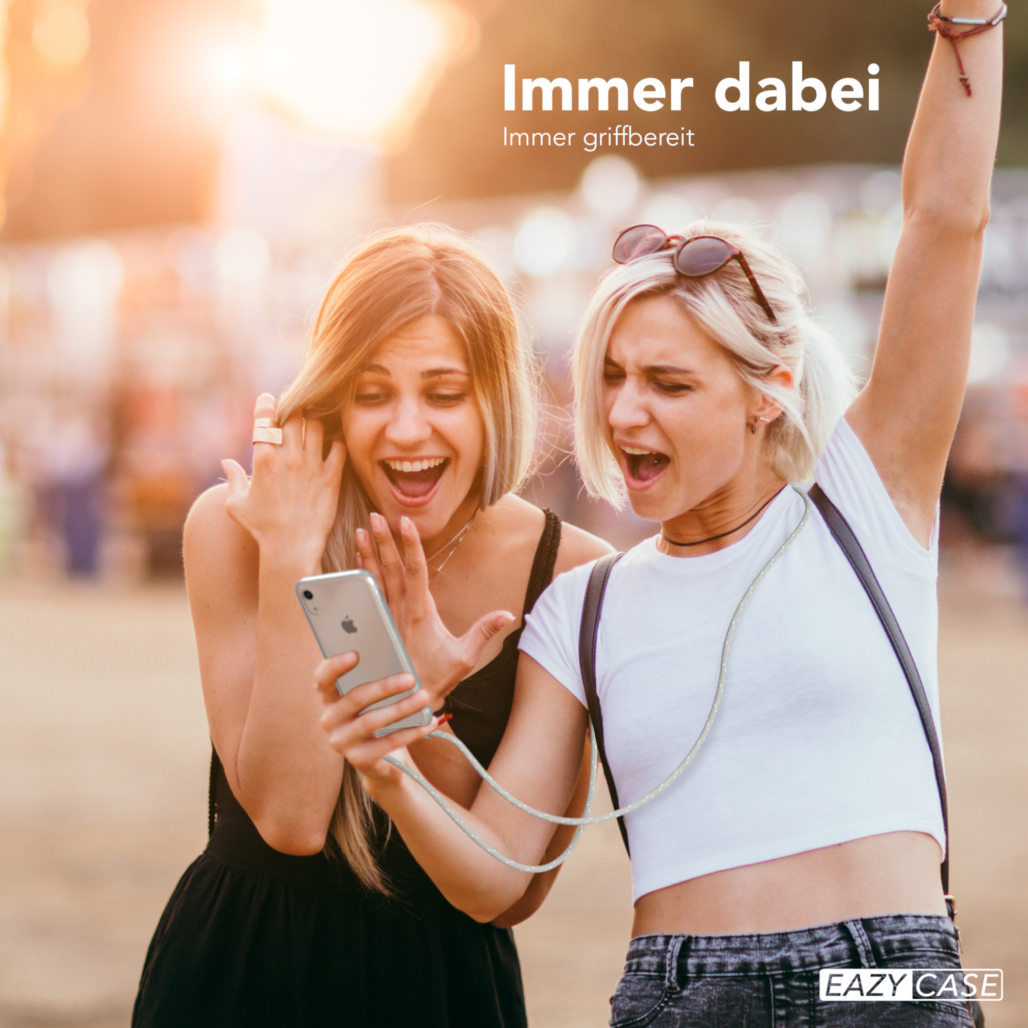Zwei Frauen schauen auf ein Telefon, eine feiert. Text: Immer dabei.