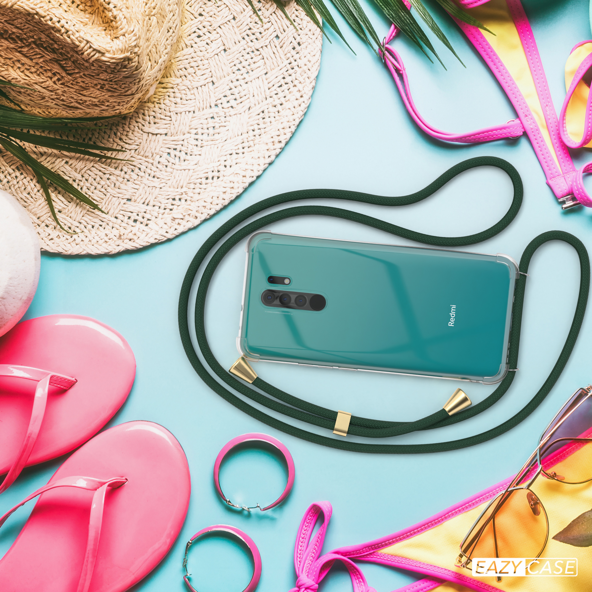 Telefon mit grünem Riemen, umgeben von Strandaccessoires. Hellblauer Hintergrund.